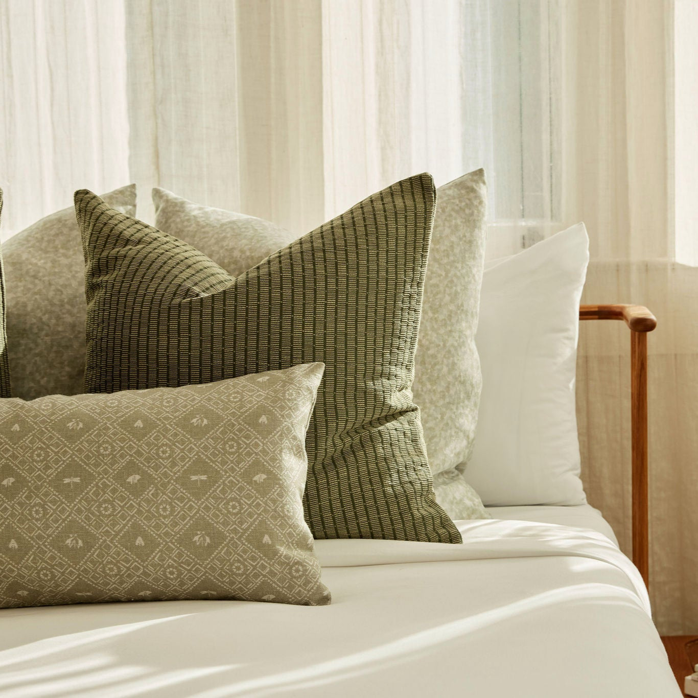 Americana pillow in Edamame styled by Emily Daws – shown on a rustic bench with handmade quilts