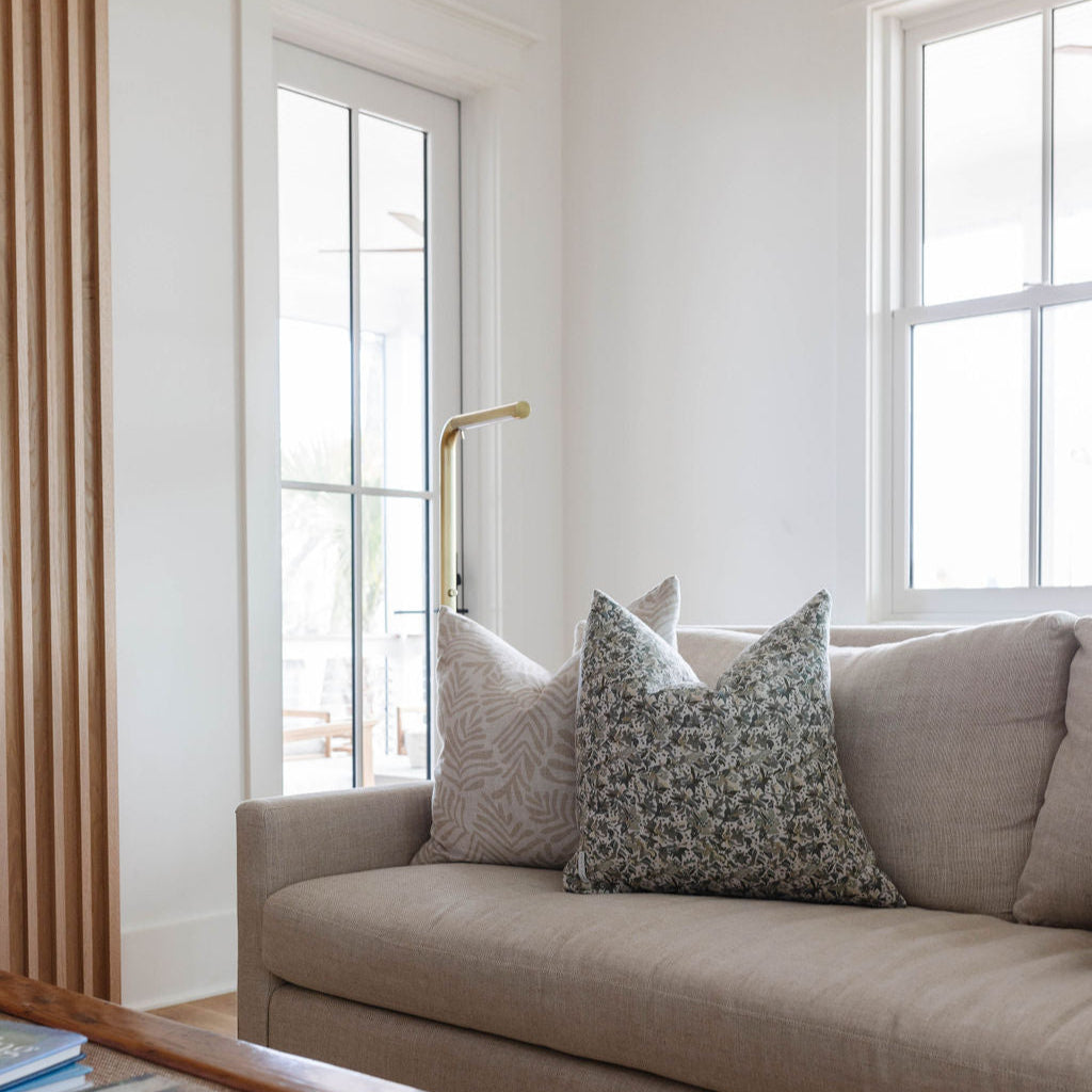 Frond pillow in Truffle styled by Emily Daws – placed on a vintage chair with warm wood tones