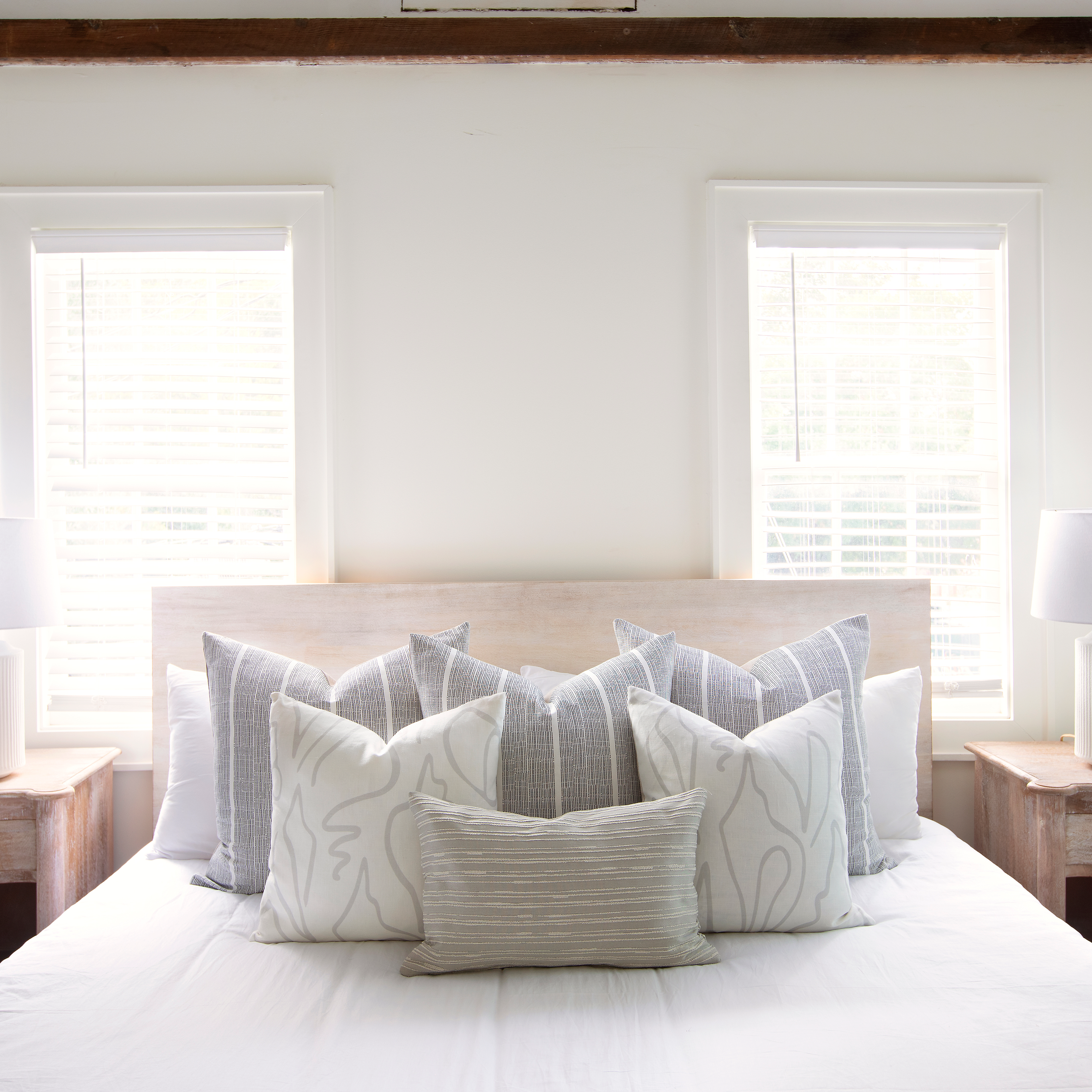 Sandbar pillow in Jet styled by Emily Daws β placed on a cane chair in a Charleston sunroom