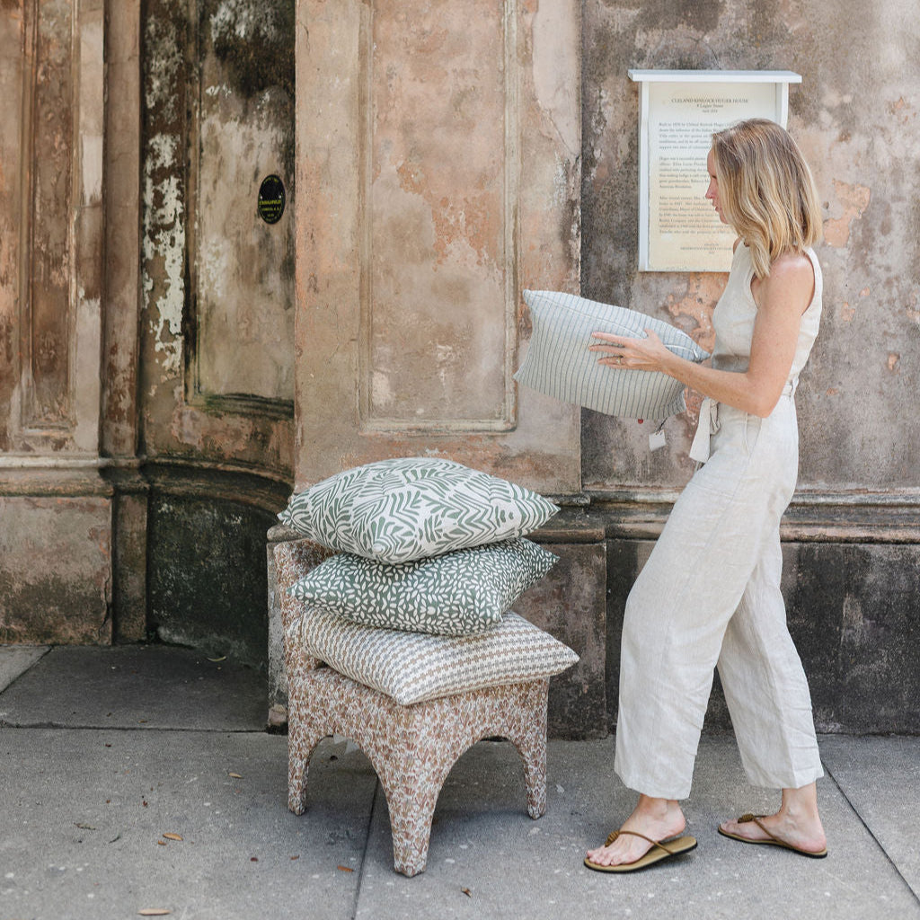 Stacked decorative pillows by Emily Daws, styled to showcase heirloom-inspired fabrics and boutique interiors.