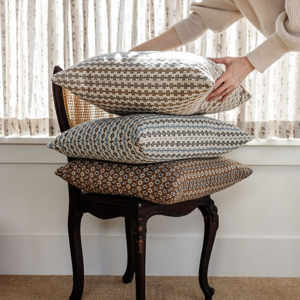Decorative pillow stack by Emily Daws featuring small-batch woven fabrics and Southern-inspired design details.