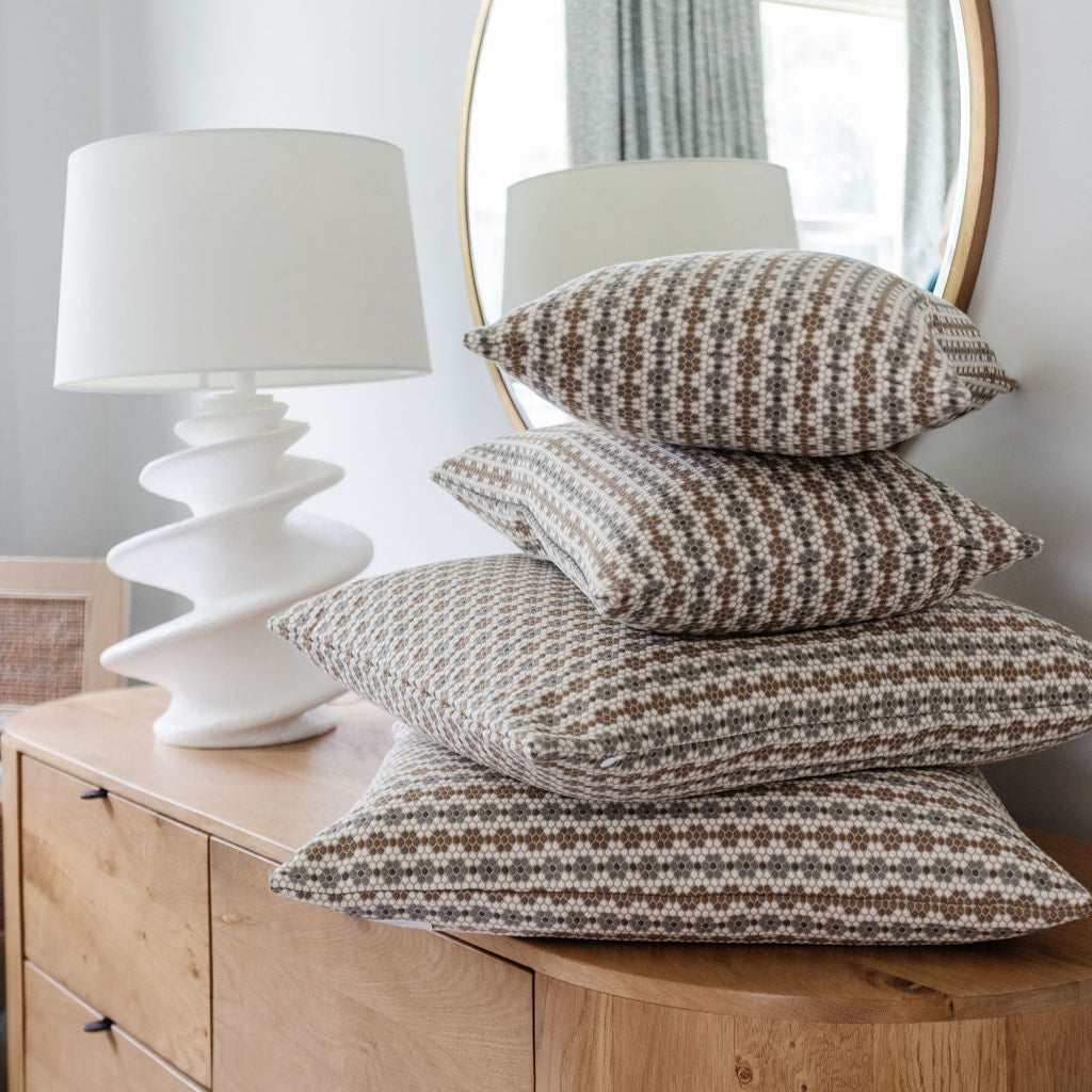 Emily Daws pillows arranged in a stacked display, featuring Southern-inspired patterns for intentional interiors.