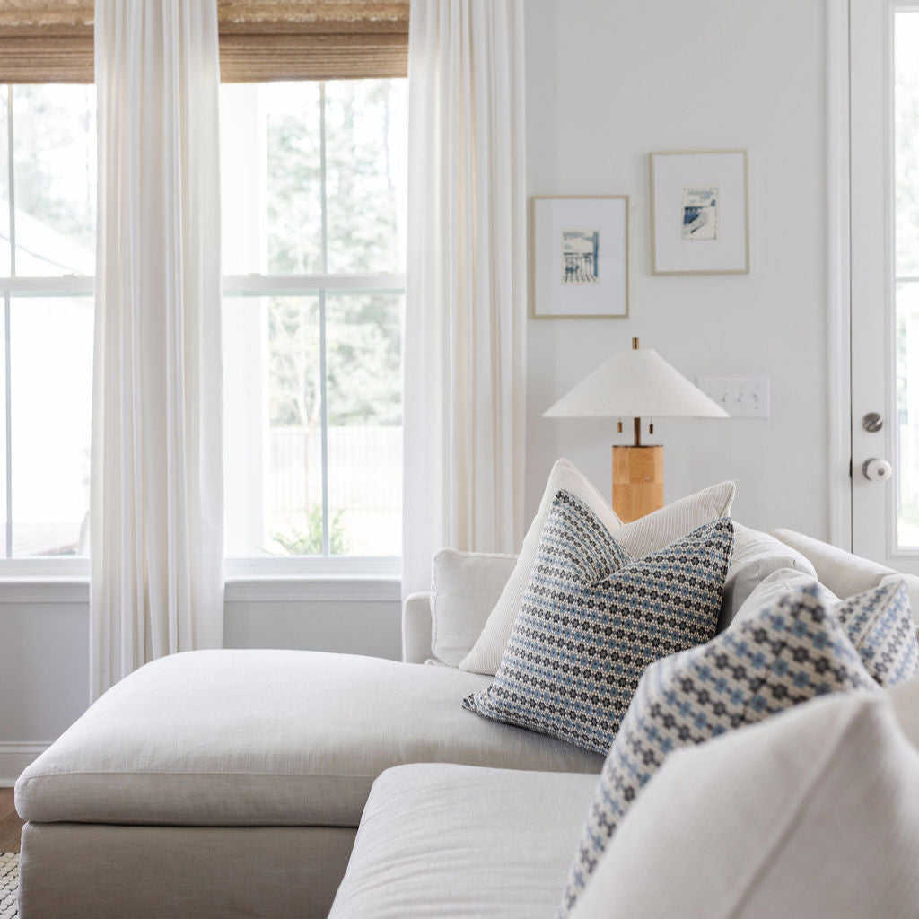 Sofa styled with Emily Daws pillows in artisanal fabrics, offering layered texture and color for interior designers.