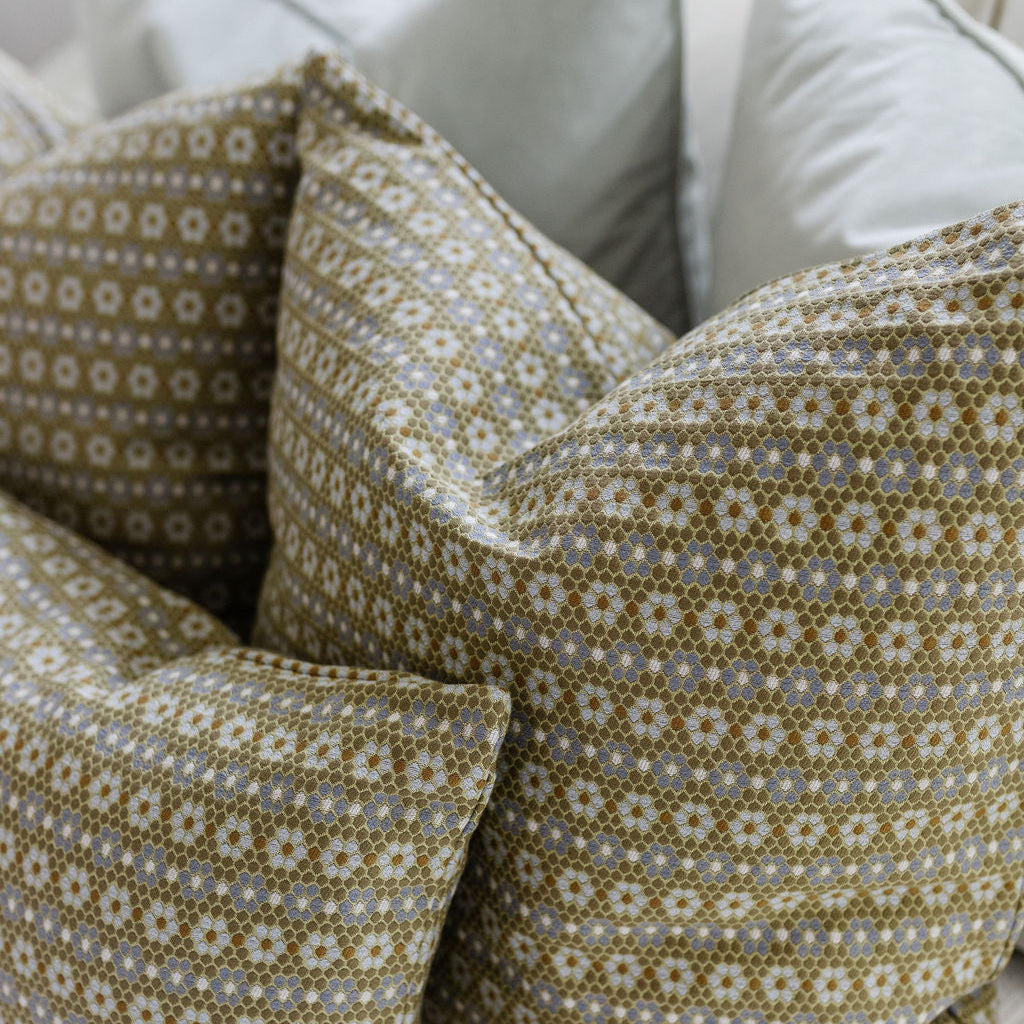 Close up of Emily Daws Nectar pillows in Savannah styled on a bed. Boutique fabrics, offering texture and warmth for refined spaces.