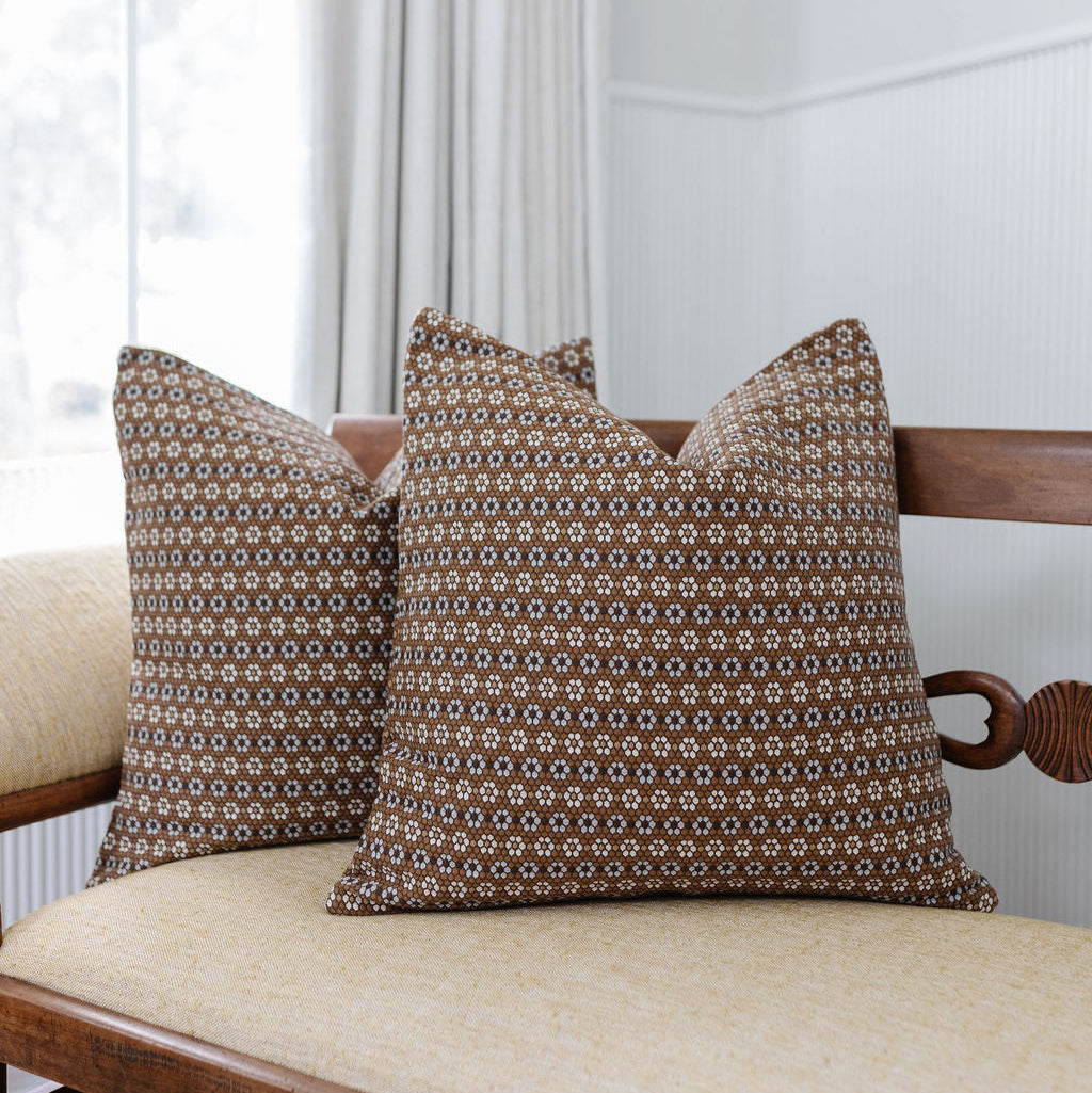 Pair of Emily Daws pillows on a bench, crafted in woven fabrics and styled for classic, artful Southern interiors.