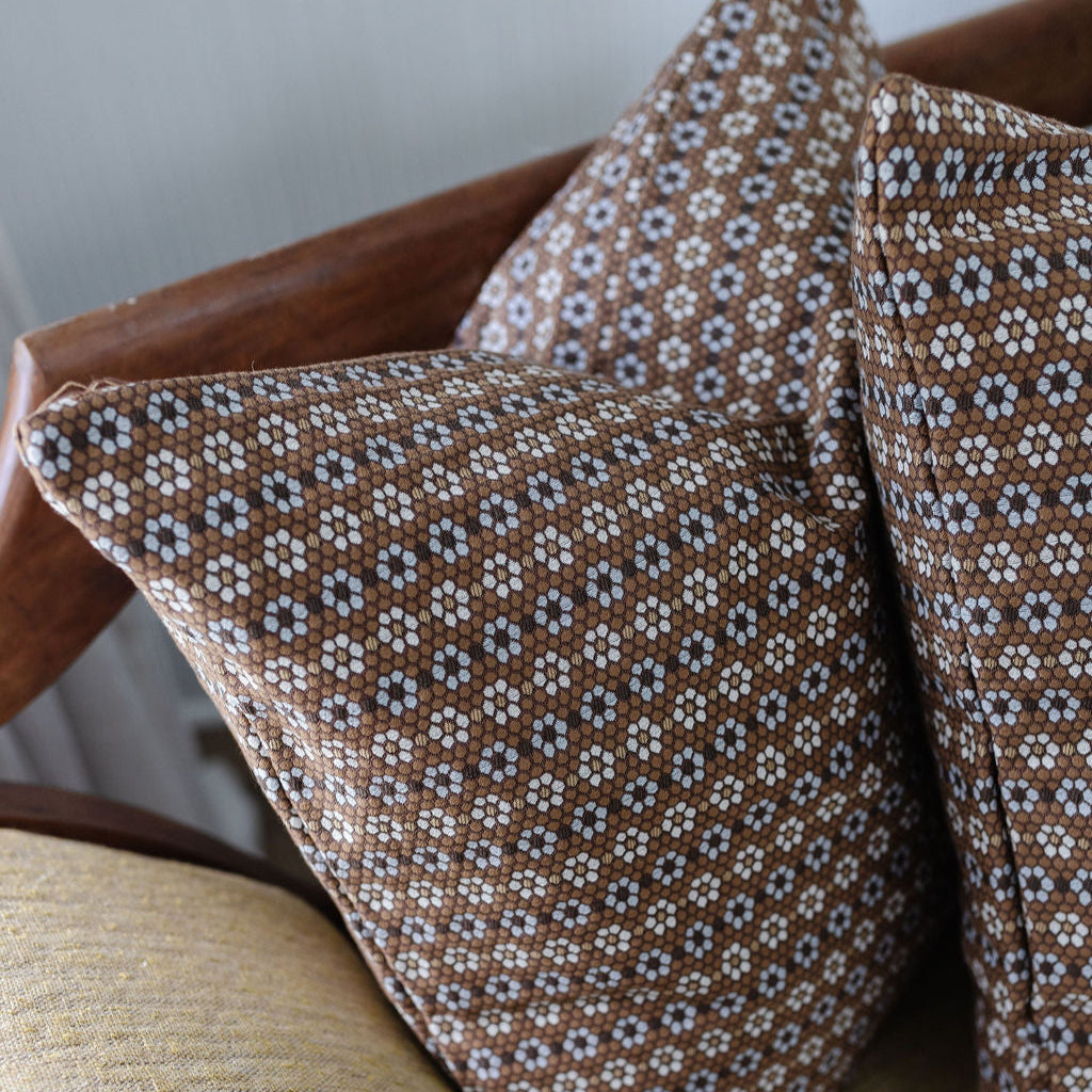 Emily Daws Nectar pillows in Walnut styled on a bench, artisanal fabrics adding southern inspired charm to a cozy living space.