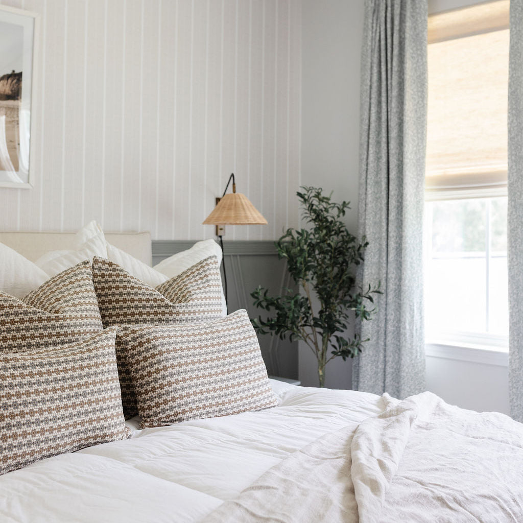 Emily Daws Nectar pillows in Raisin arranged on a bed, styled to highlight small-batch fabrics and bespoke interiors.