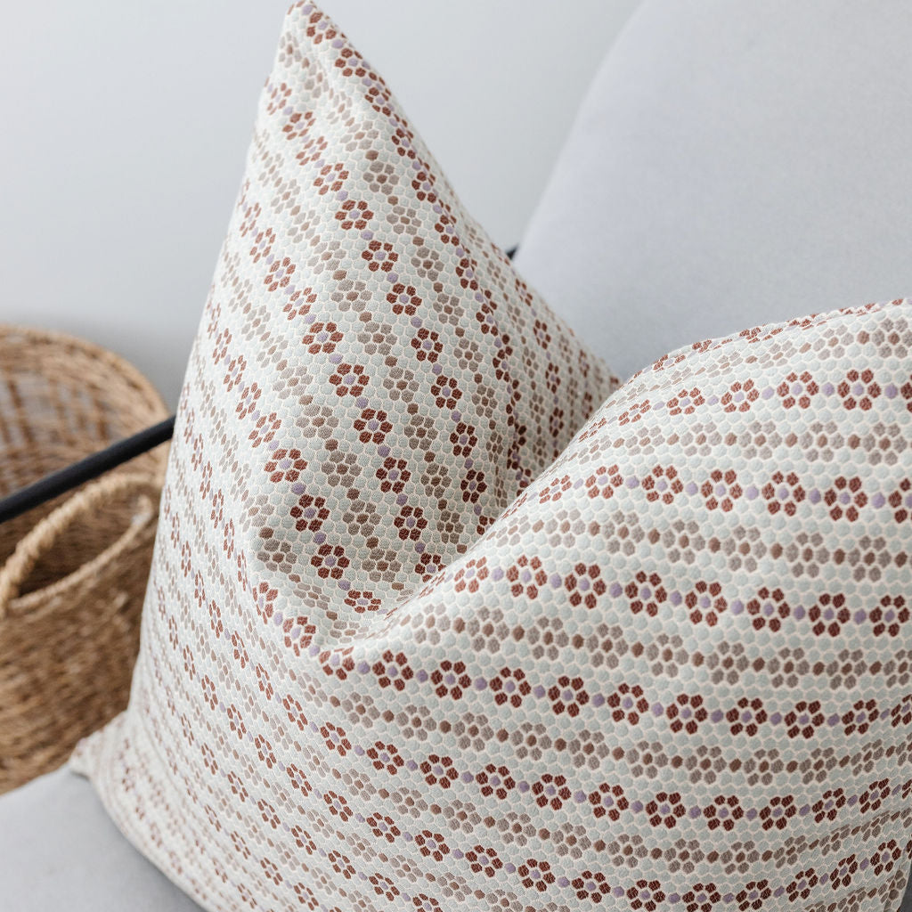 Close-up of armchair styled with Emily Daws Nectar Sugar Plum pillows, featuring handcrafted details and woven fabrics for classic interiors.