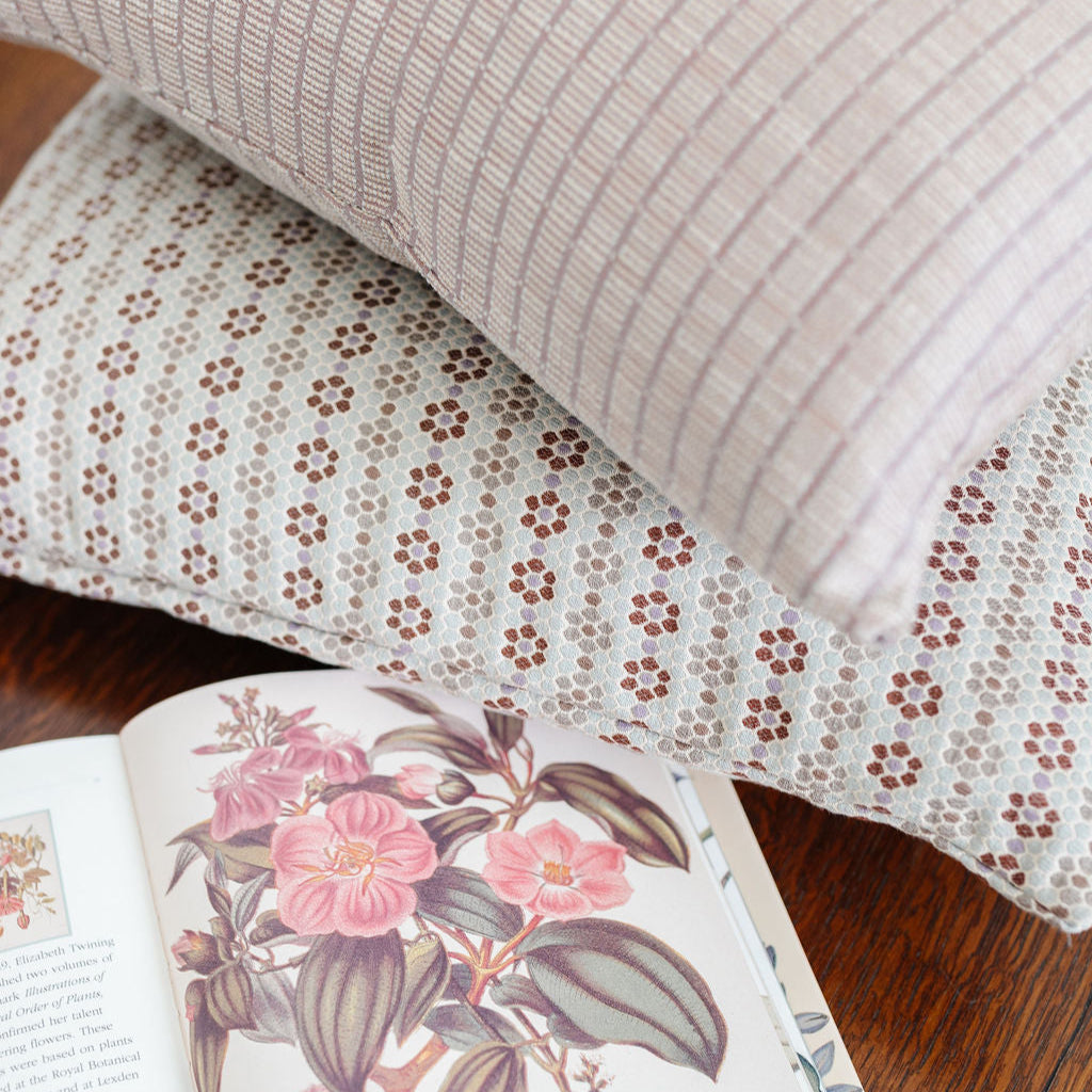 Emily Daws Nectar Sugar Plum pillow styled alongside coordinating woven pillows, perfect for layered living rooms and bedrooms. A Southern-inspired design that blends organic texture with timeless style.