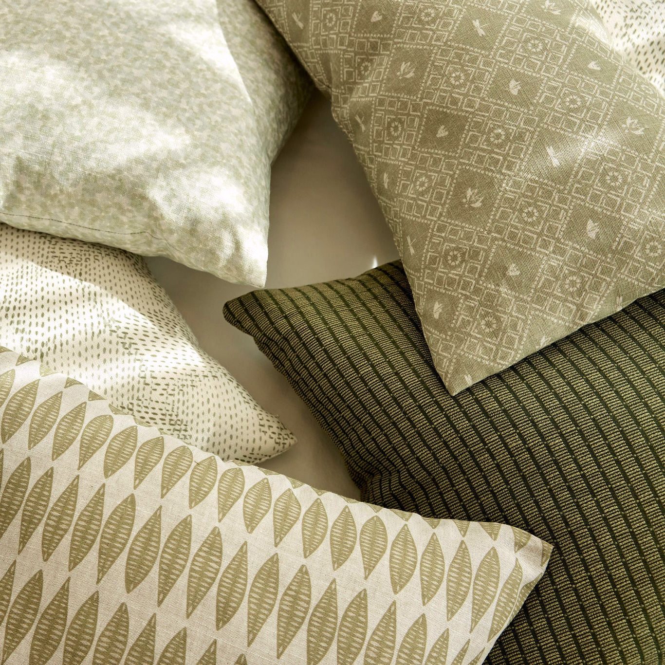 Emily Daws pillows styled in layered tones and textures, crafted for Southern-inspired interiors and cozy spaces.