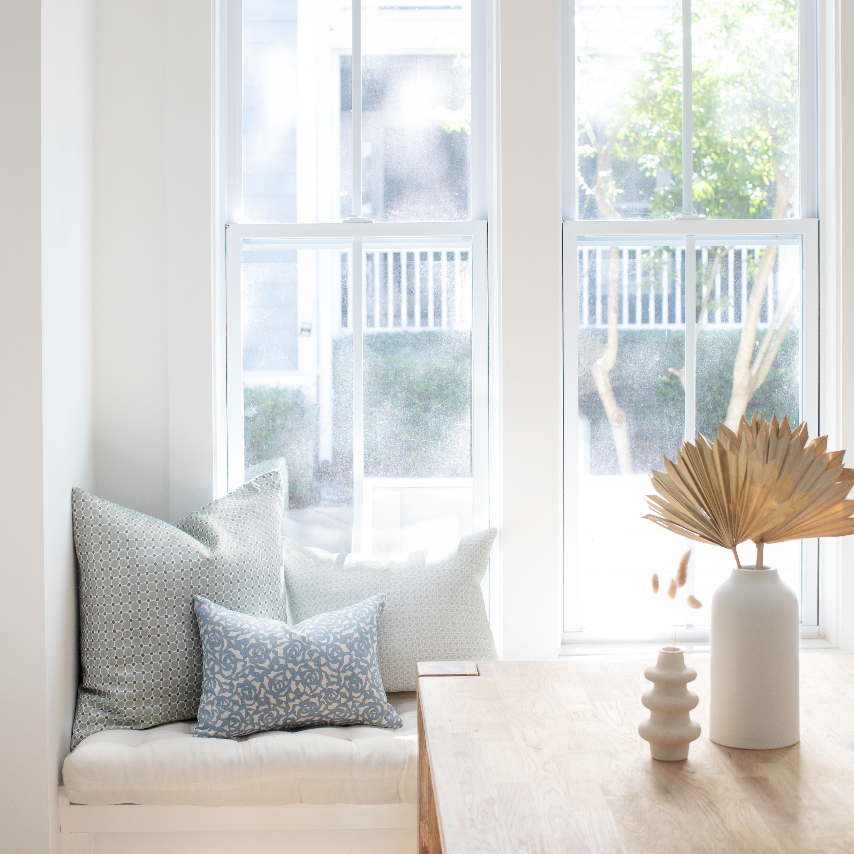 Emily Daws pillows styled in a living room with layered fabrics and patterns, designed for luxury interiors.