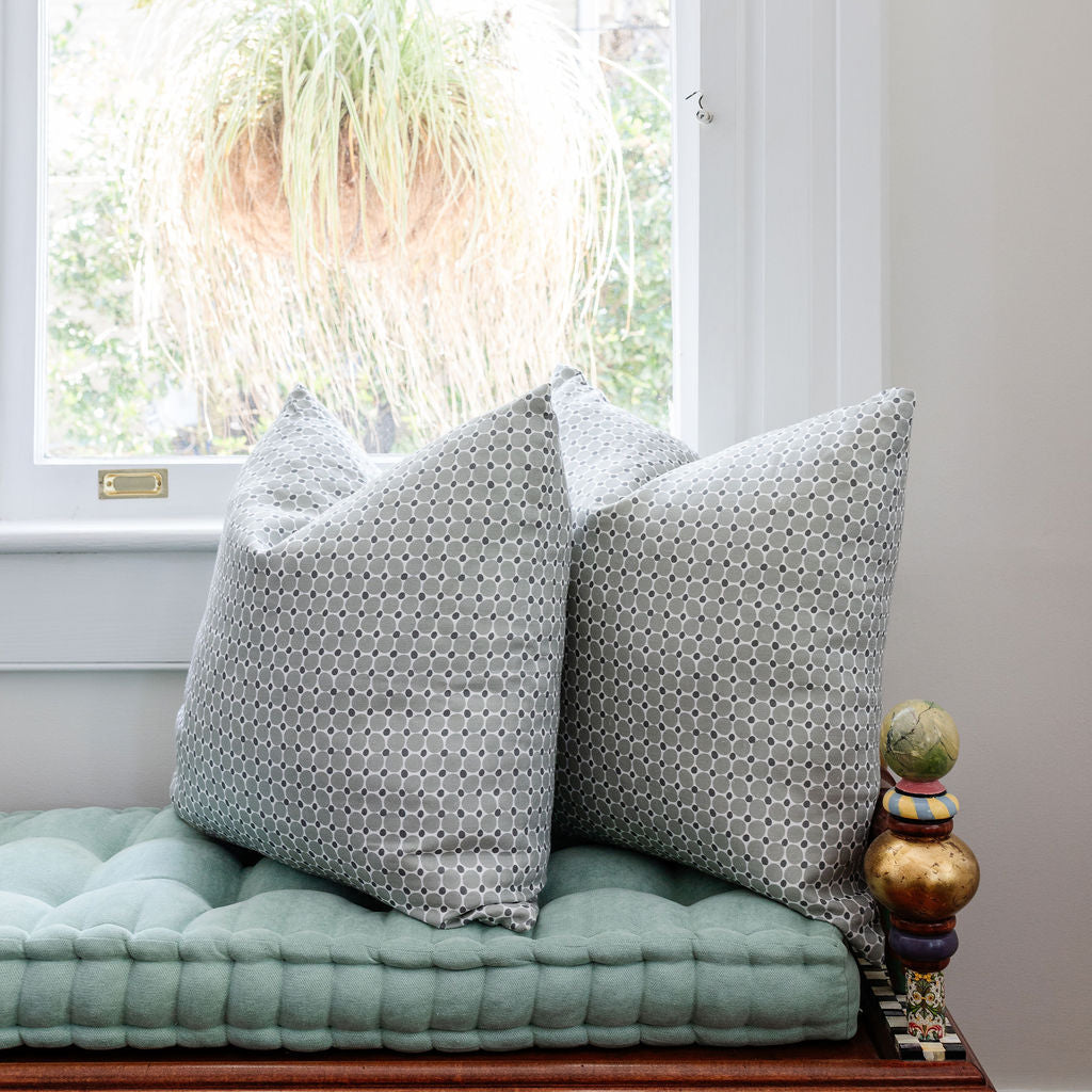 Accent pillows by Emily Daws styled on a window seat, designed for cozy spaces and bespoke interiors.