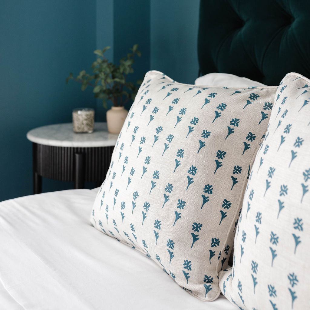 Bedroom vignette featuring Emily Daws pillows, styled with heirloom-inspired fabrics for boutique interiors.