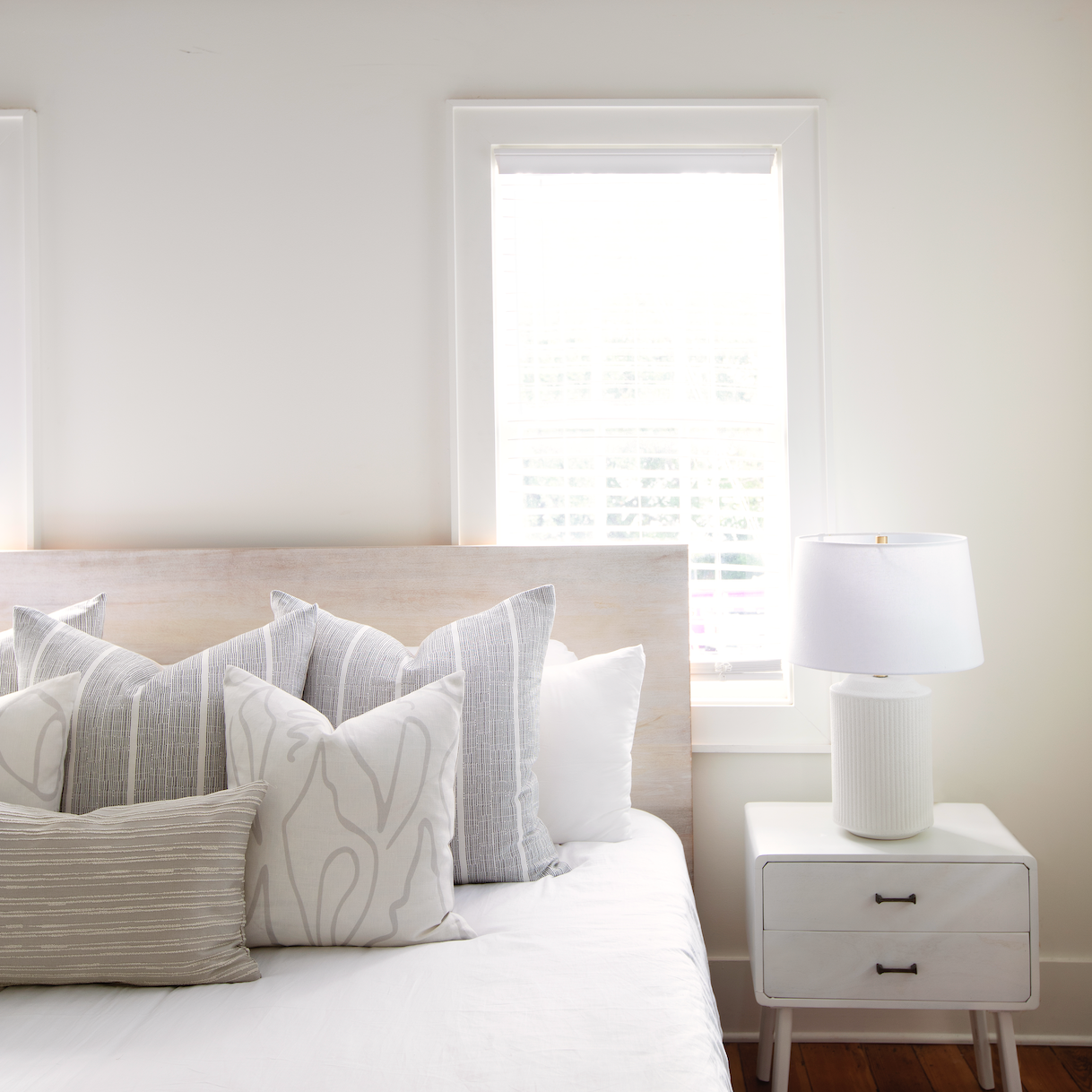 Neutral Emily Daws pillows arranged on a bed, styled to highlight small-batch fabrics and bespoke interiors.