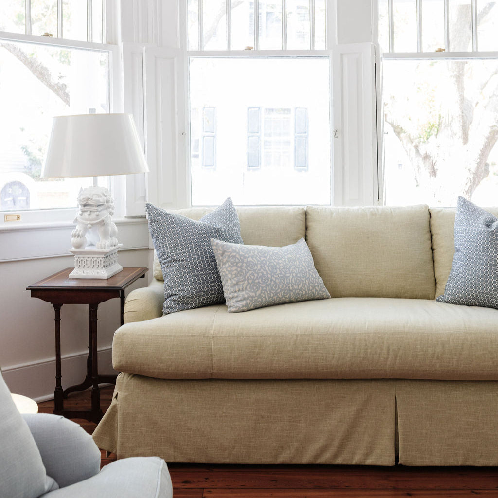Sofa styled with Emily Daws pillows in artisanal fabrics, offering layered texture and color for interior designers.