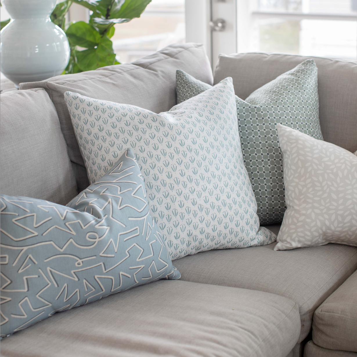 Emily Daws pillows styled in a living room with layered fabrics and patterns, designed for luxury interiors.