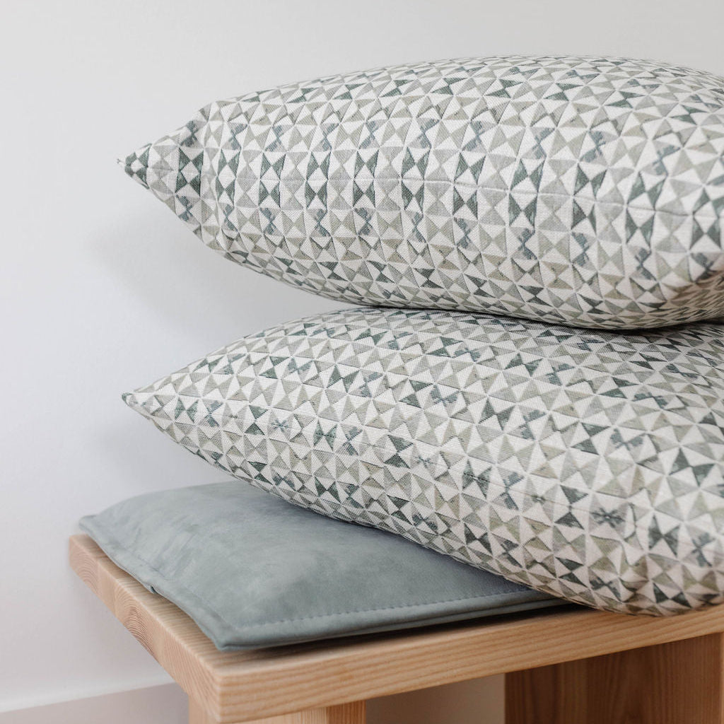 Accent pillows by Emily Daws styled on a window seat, designed for cozy spaces and bespoke interiors.