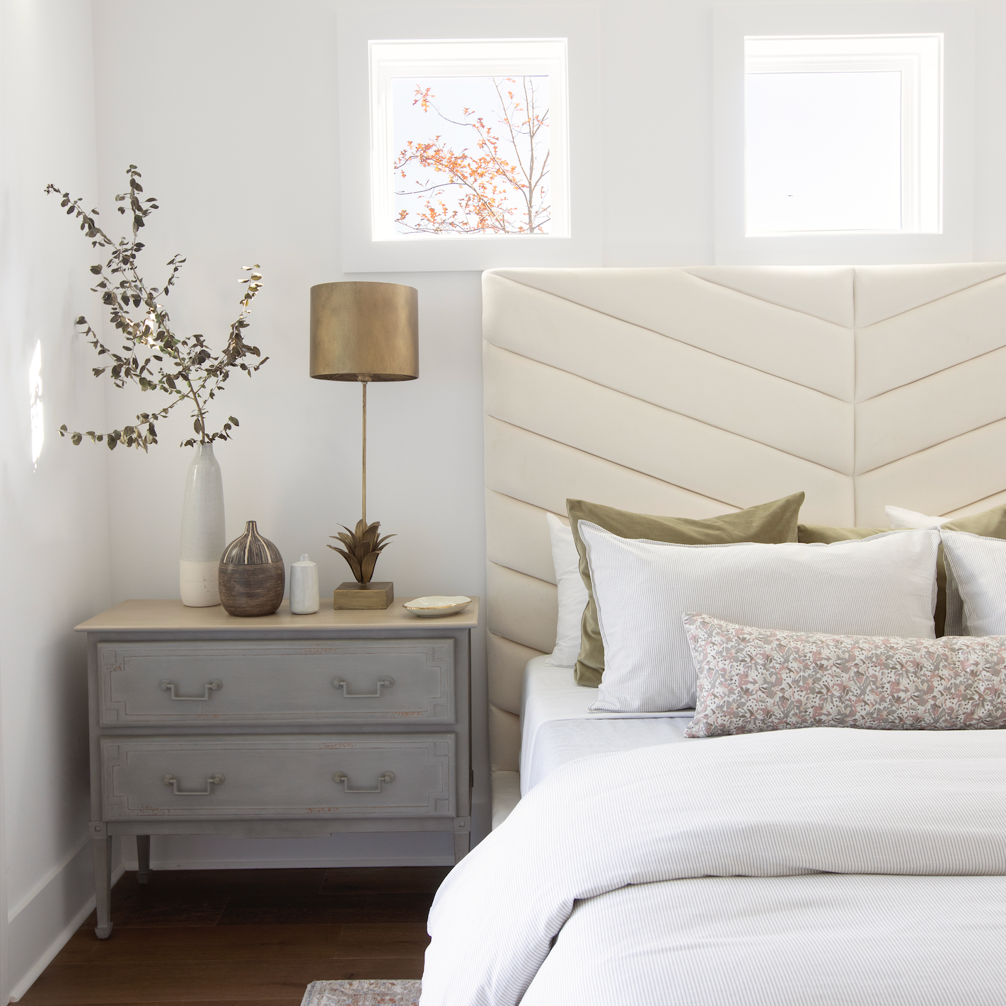Bedroom vignette featuring Emily Daws pillows, styled with heirloom-inspired fabrics for boutique interiors.