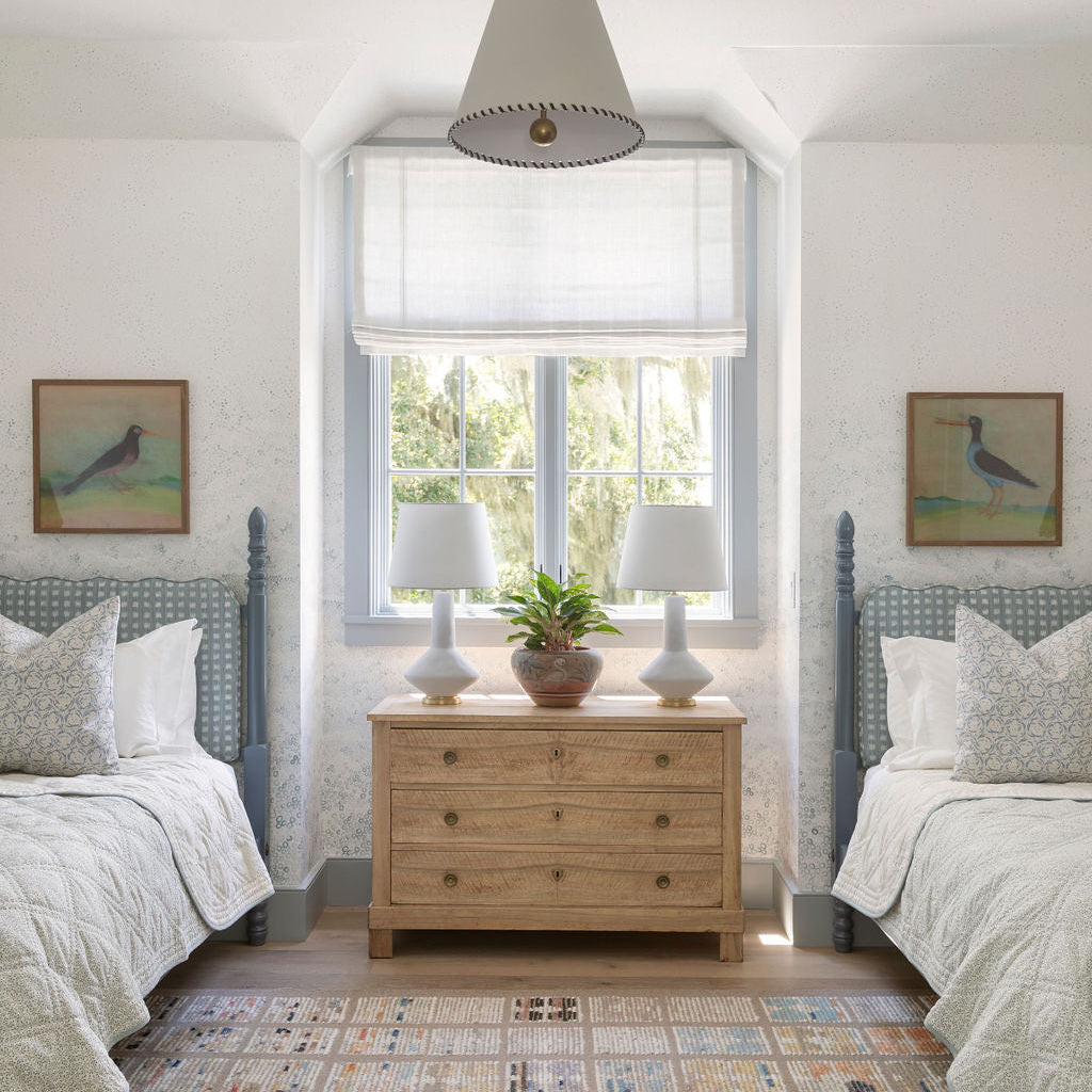 Bedroom vignette featuring Emily Daws pillows, styled with heirloom-inspired fabrics for boutique interiors.