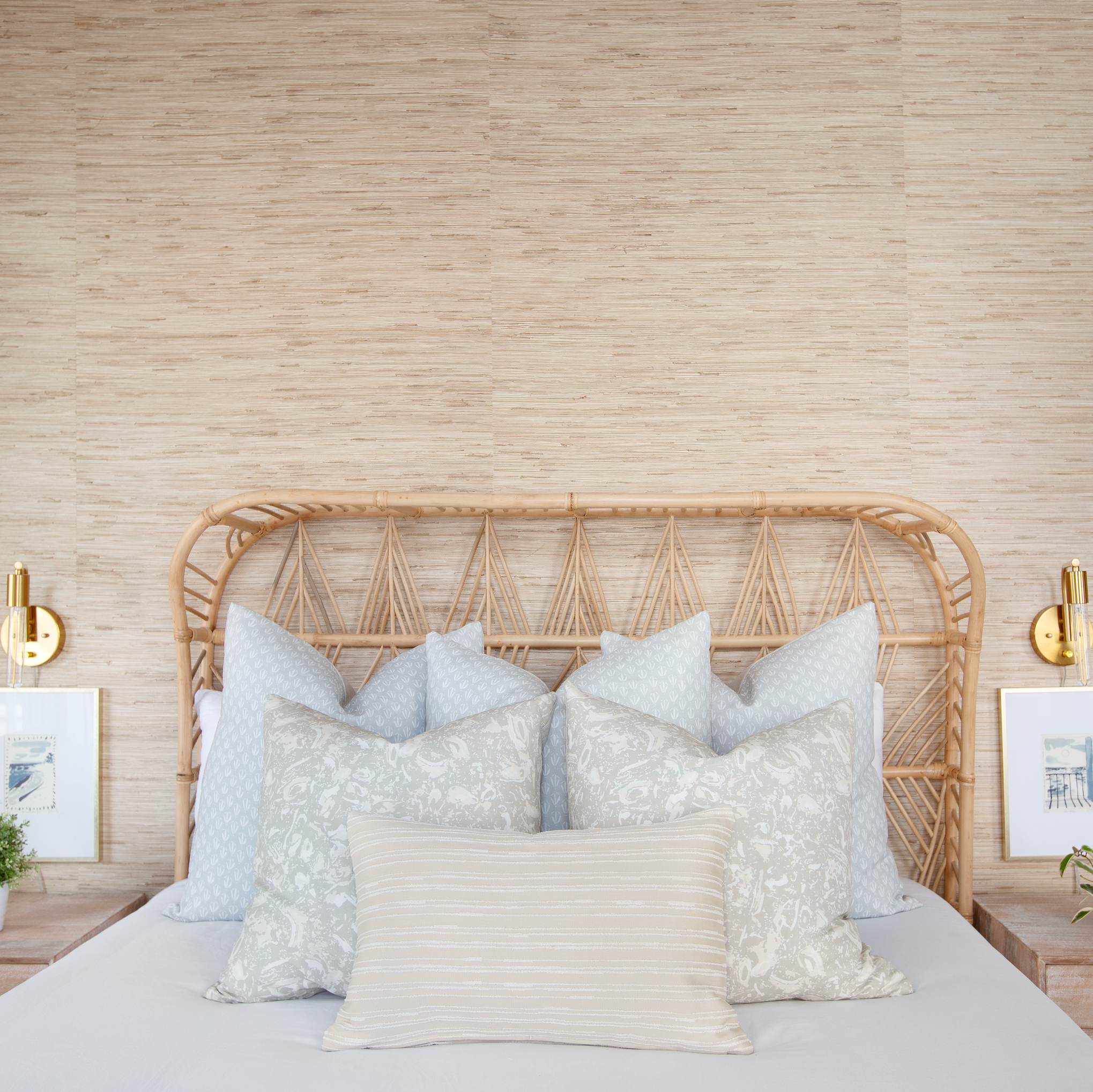 Emily Daws throw pillows layered on a bed, showcasing luxury textiles and heirloom-inspired patterns for designers.