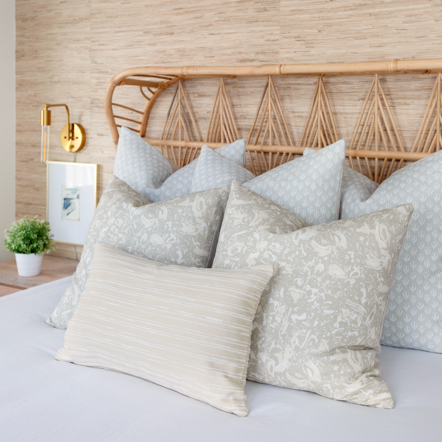 Neutral Emily Daws pillows arranged on a bed, styled to highlight small-batch fabrics and bespoke interiors.