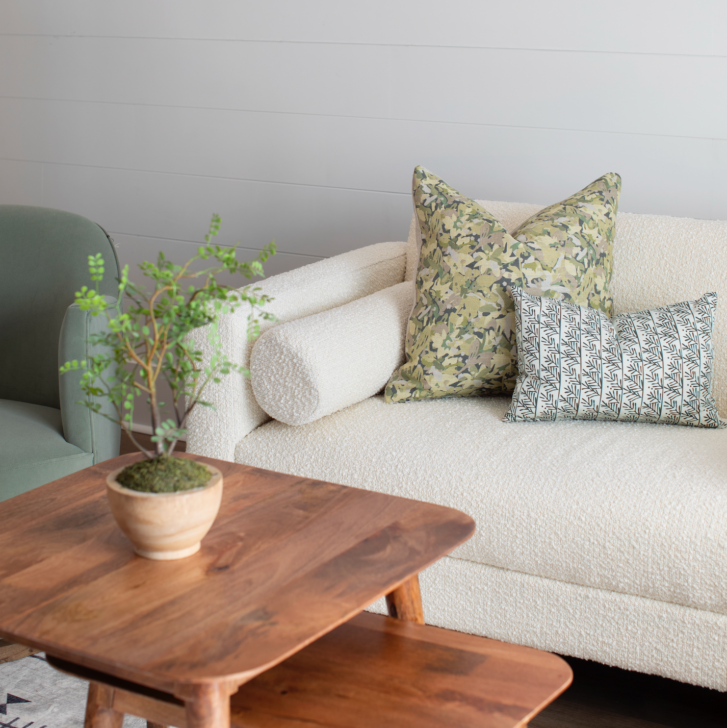Sofa styled with Emily Daws pillows in artisanal fabrics, offering layered texture and color for interior designers.