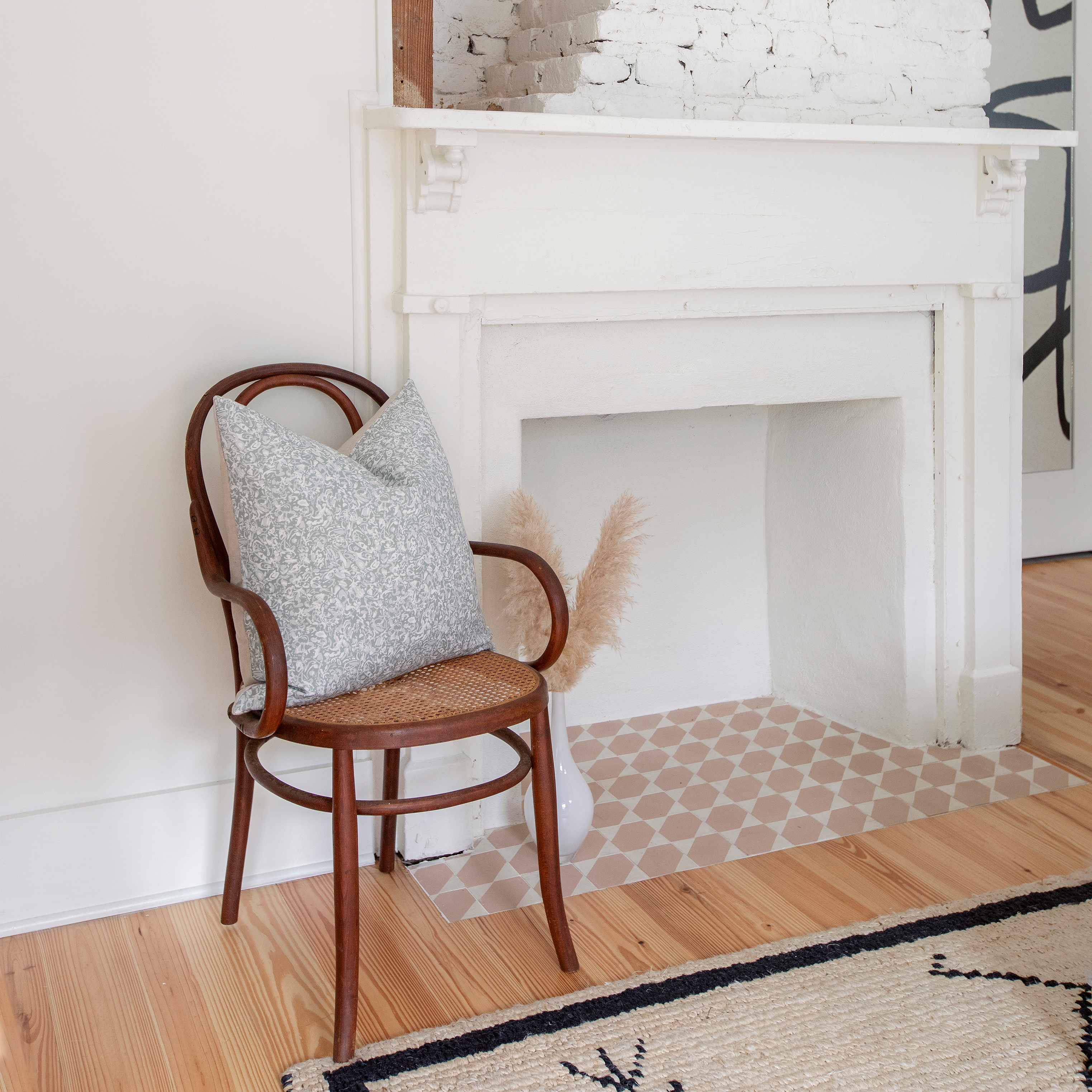 Estuary pillow in Artichoke styled by Emily Daws – placed on a cane chair in a Charleston sunroom