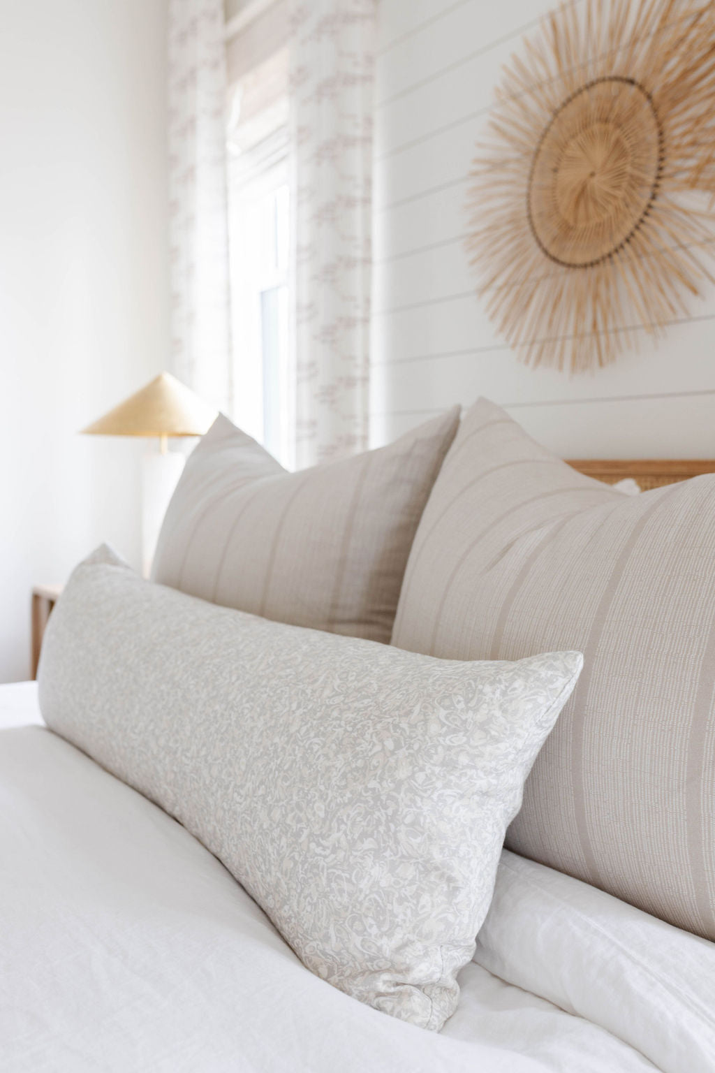 Estuary pillow in Drift styled by Emily Daws – placed on a cane chair in a Charleston sunroom