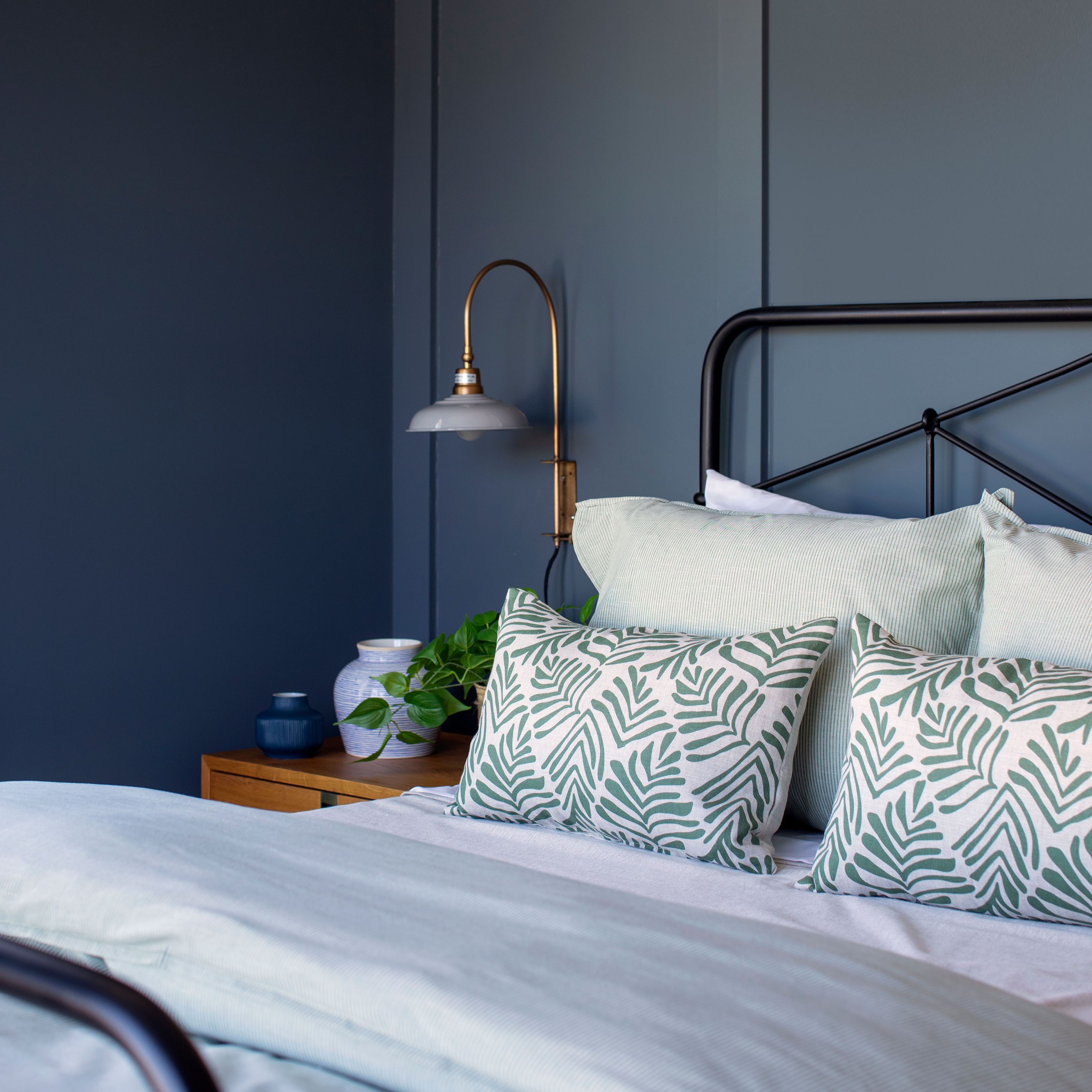 Frond pillow in Alpine styled by Emily Daws – placed on a vintage chair with warm wood tones