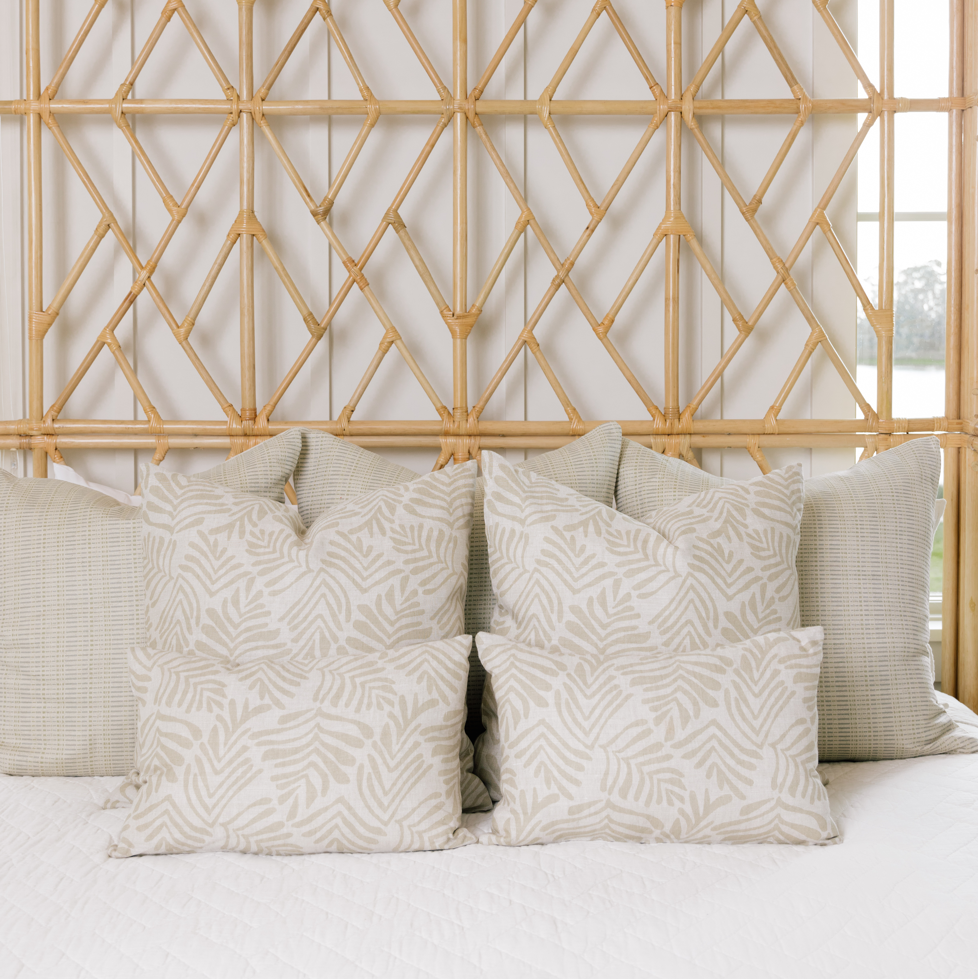 Frond pillow in Truffle styled by Emily Daws β layered with quilts in a woodland bedroom setting