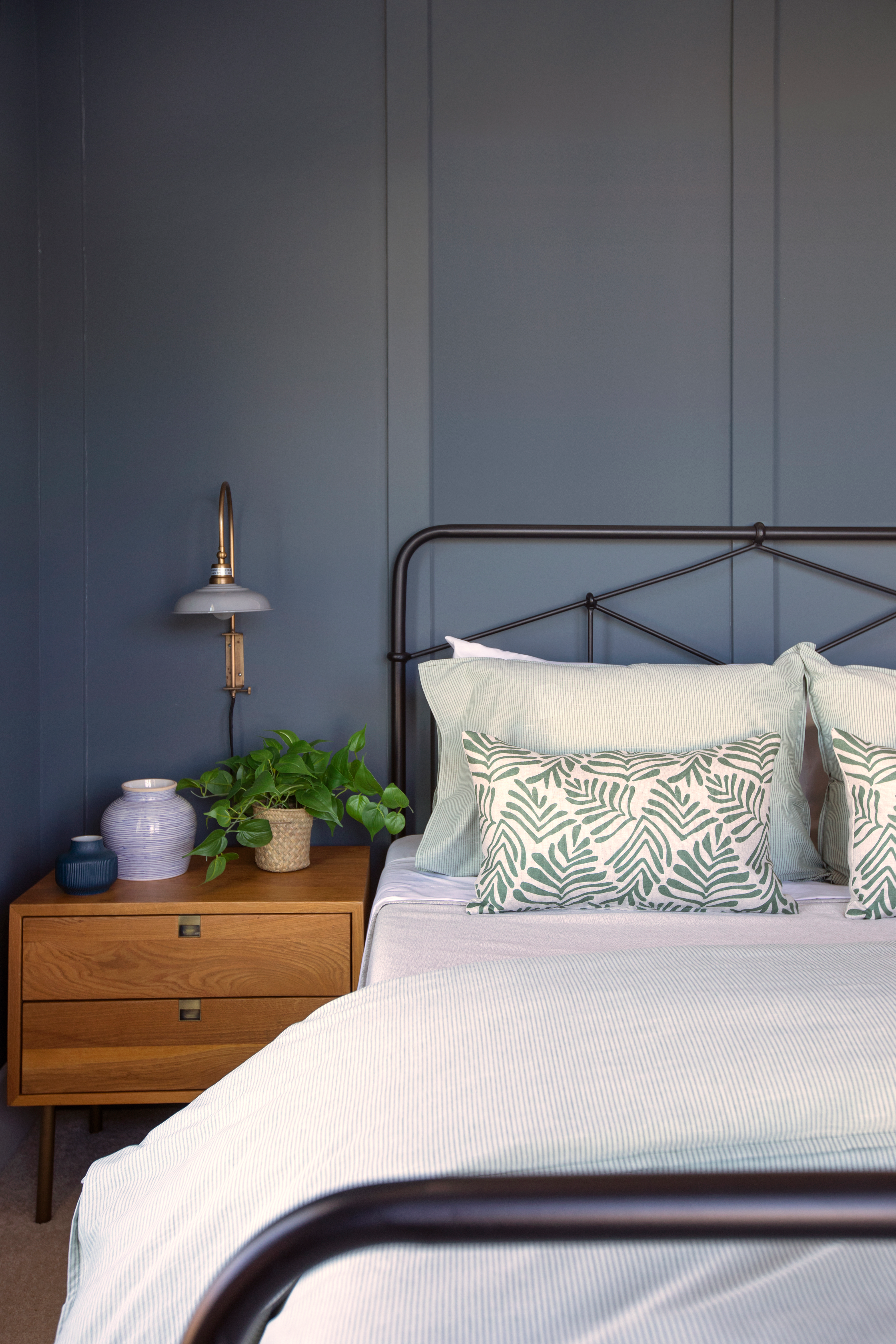 Frond pillow in Alpine styled by Emily Daws – layered with quilts in a woodland bedroom setting