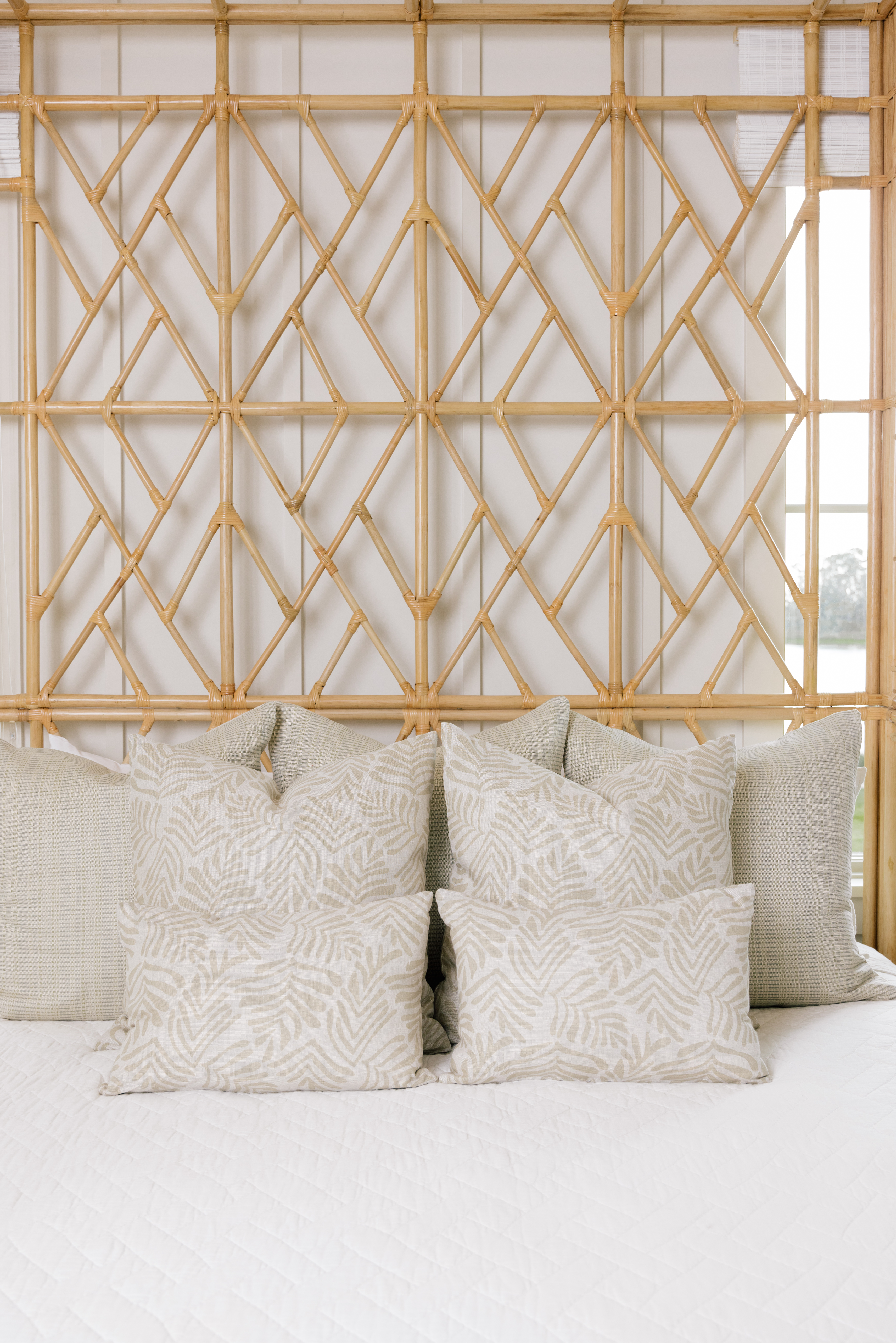 Frond pillow in Truffle styled by Emily Daws – layered with quilts in a woodland bedroom setting