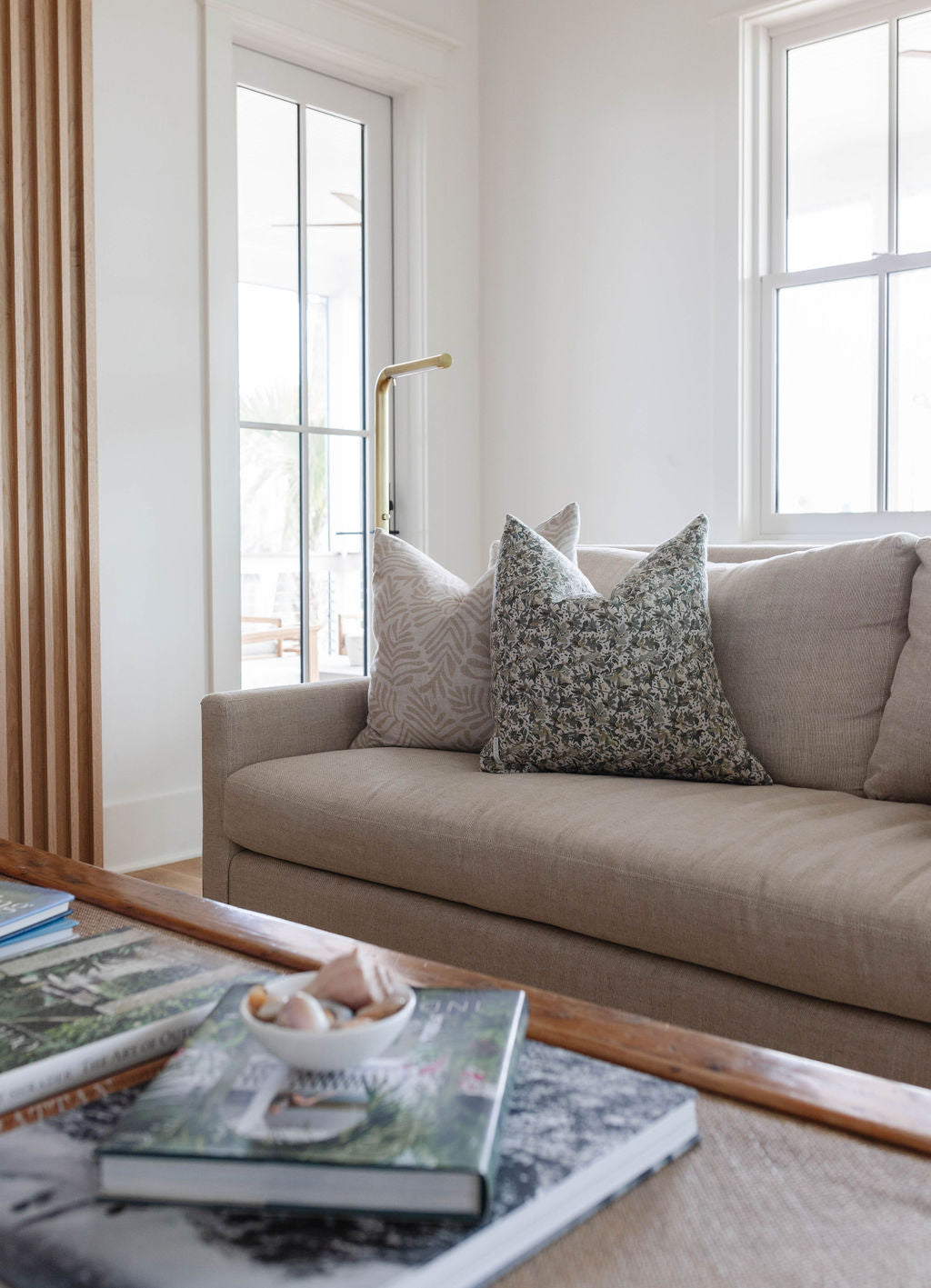 Frond pillow in Truffle styled by Emily Daws – placed on a vintage chair with warm wood tones