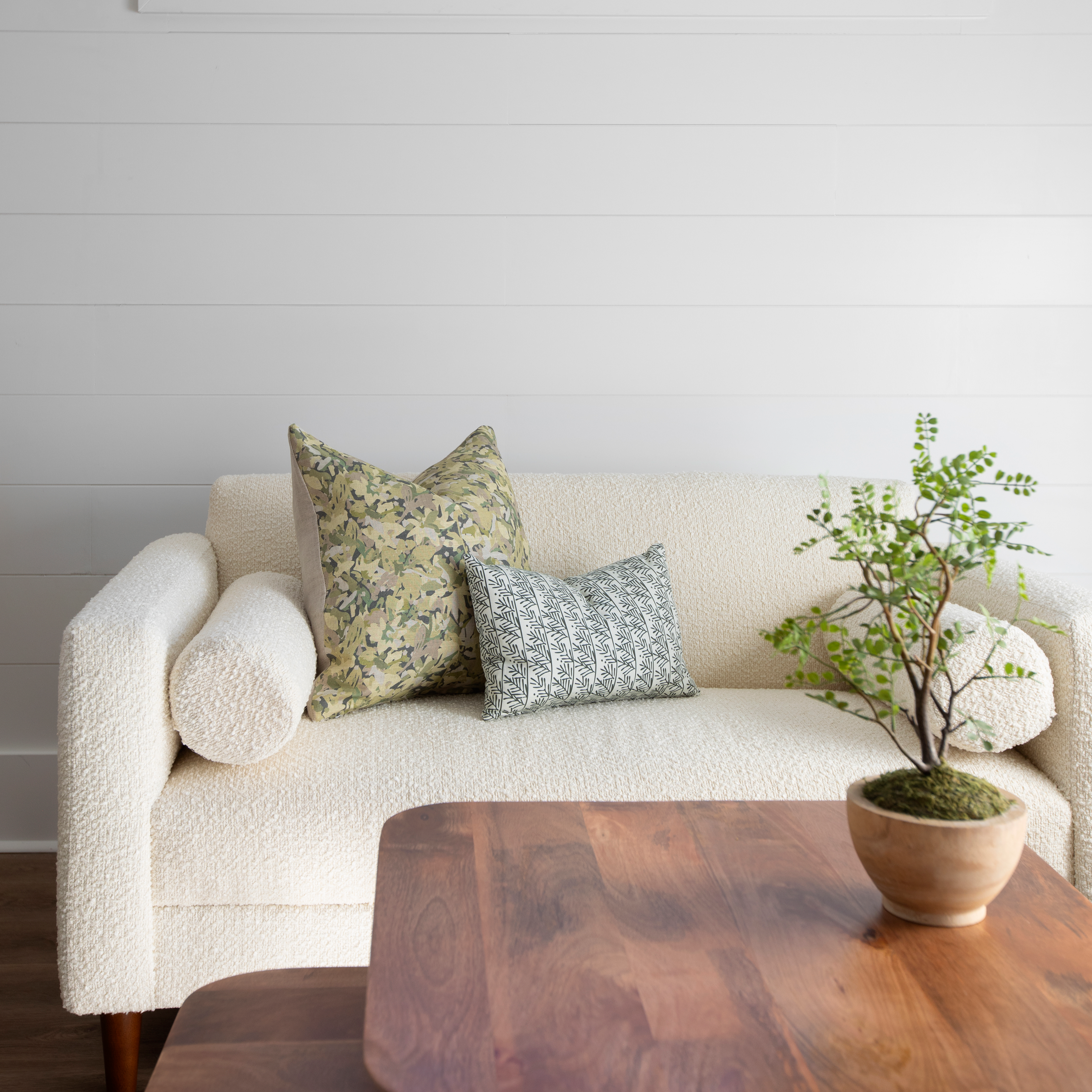 Hemlock pillow in Holly styled by Emily Daws – placed on a vintage chair with warm wood tones