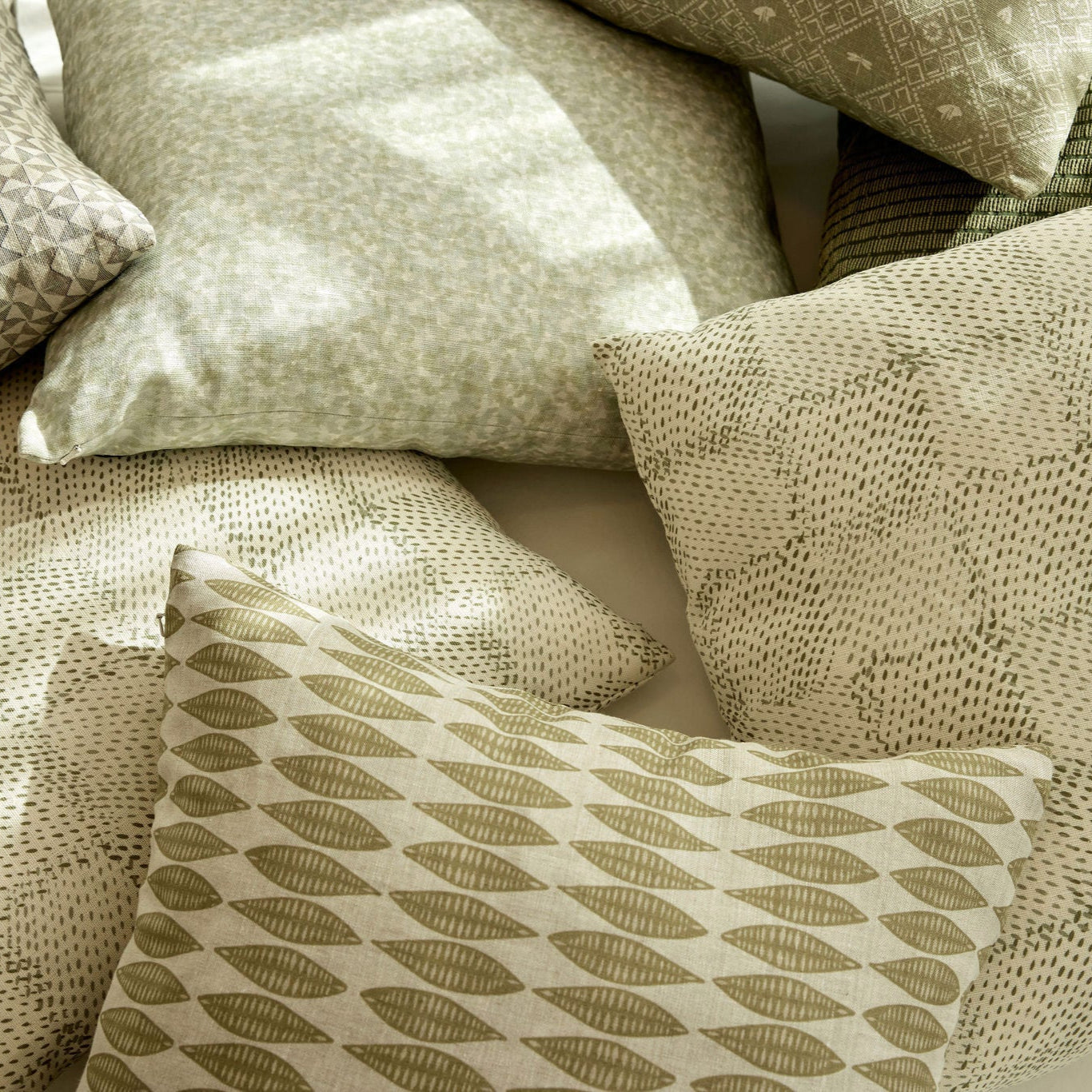 Leaflette pillow in Lemongrass styled by Emily Daws – layered with quilts in a woodland bedroom setting