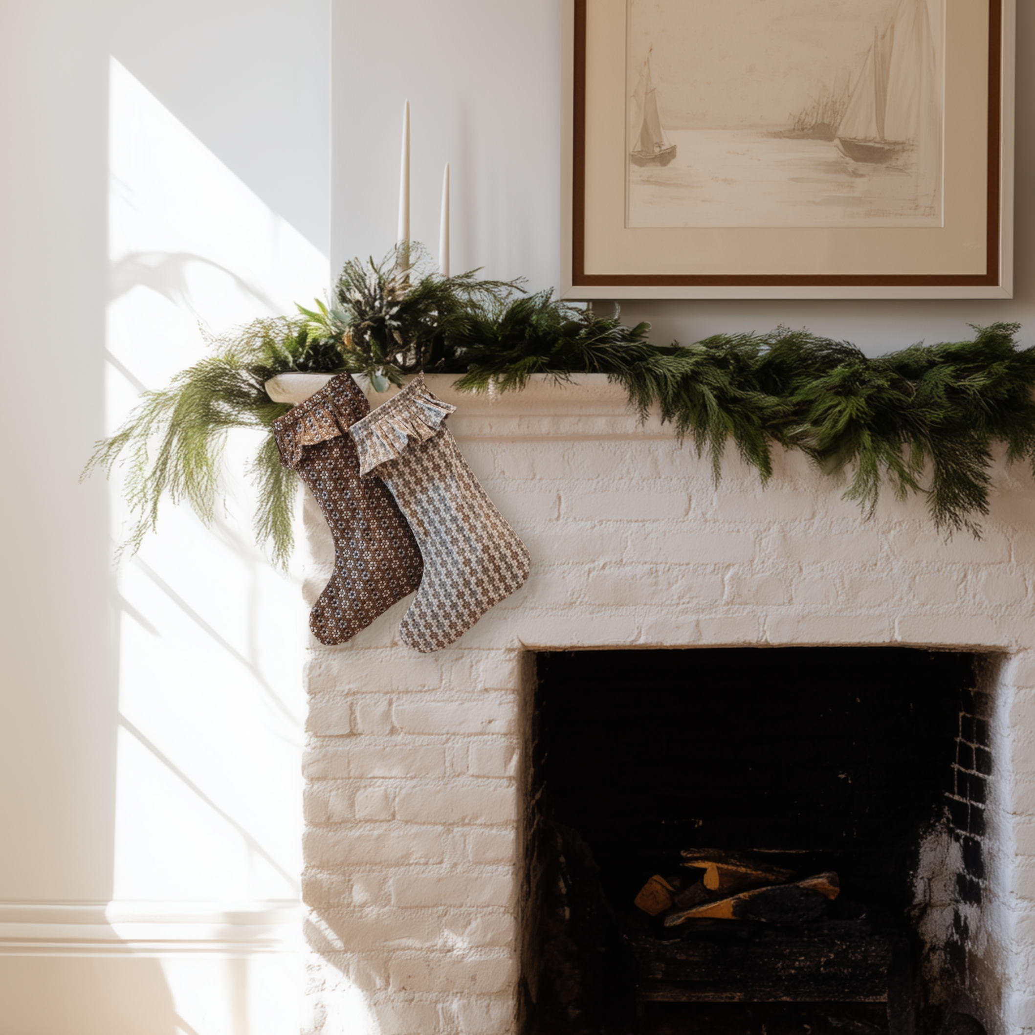 Decorative stockings hanging on a fireplace mantel with greenery and a framed picture above.