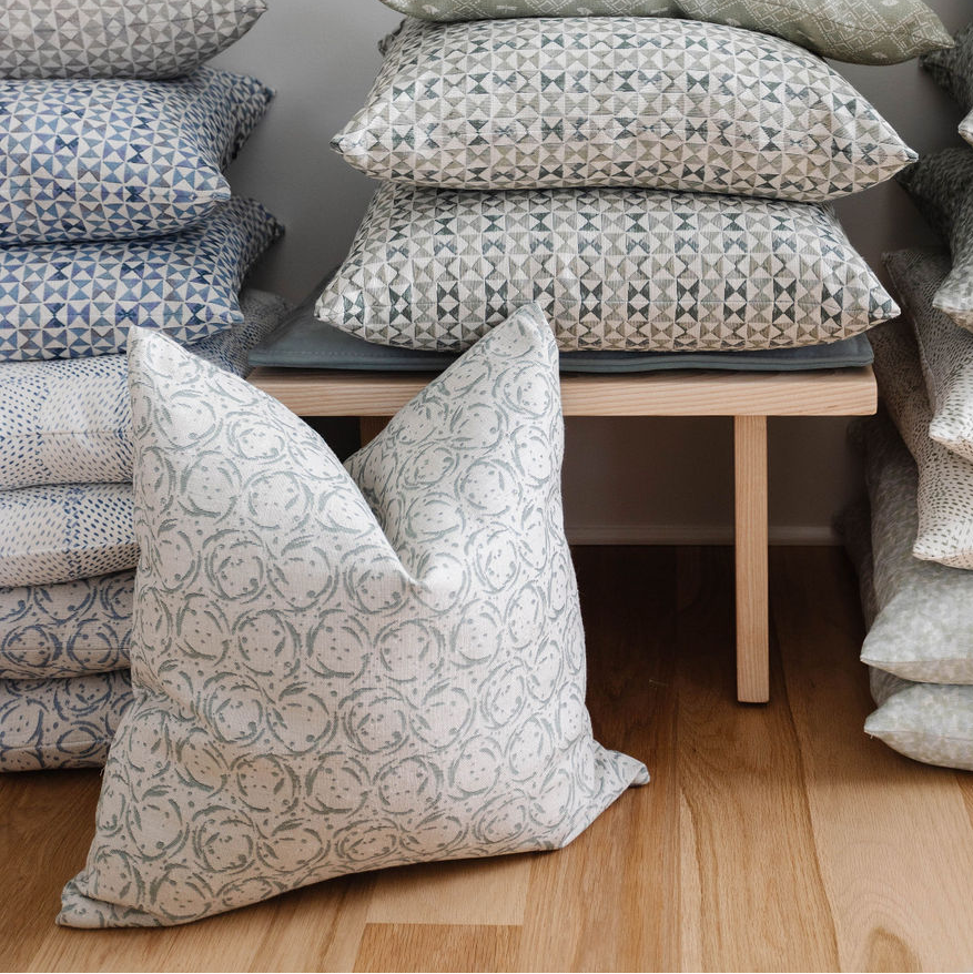 Nest pillow in Raindrop styled by Emily Daws – shown on a rustic bench with handmade quilts