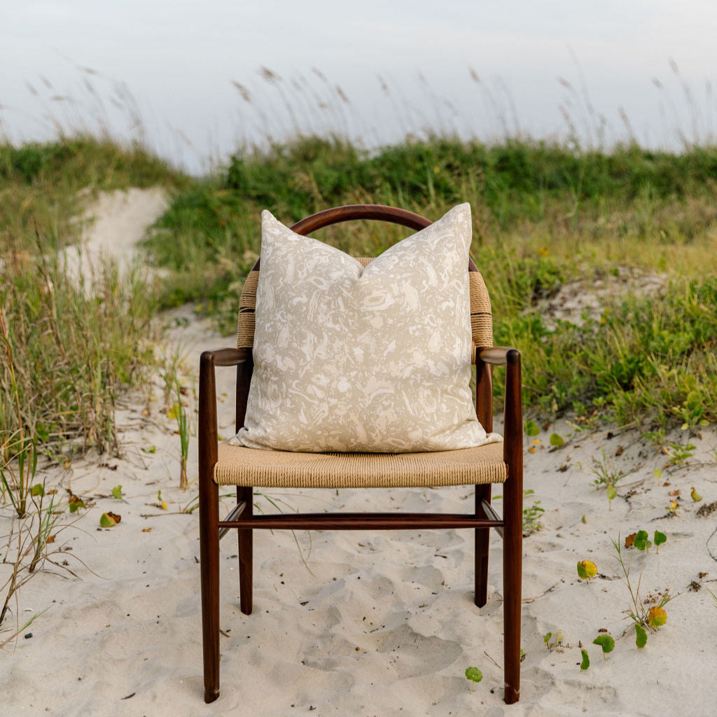 River Reef pillow in Raffia styled by Emily Daws – placed on a cane chair in a Charleston sunroom