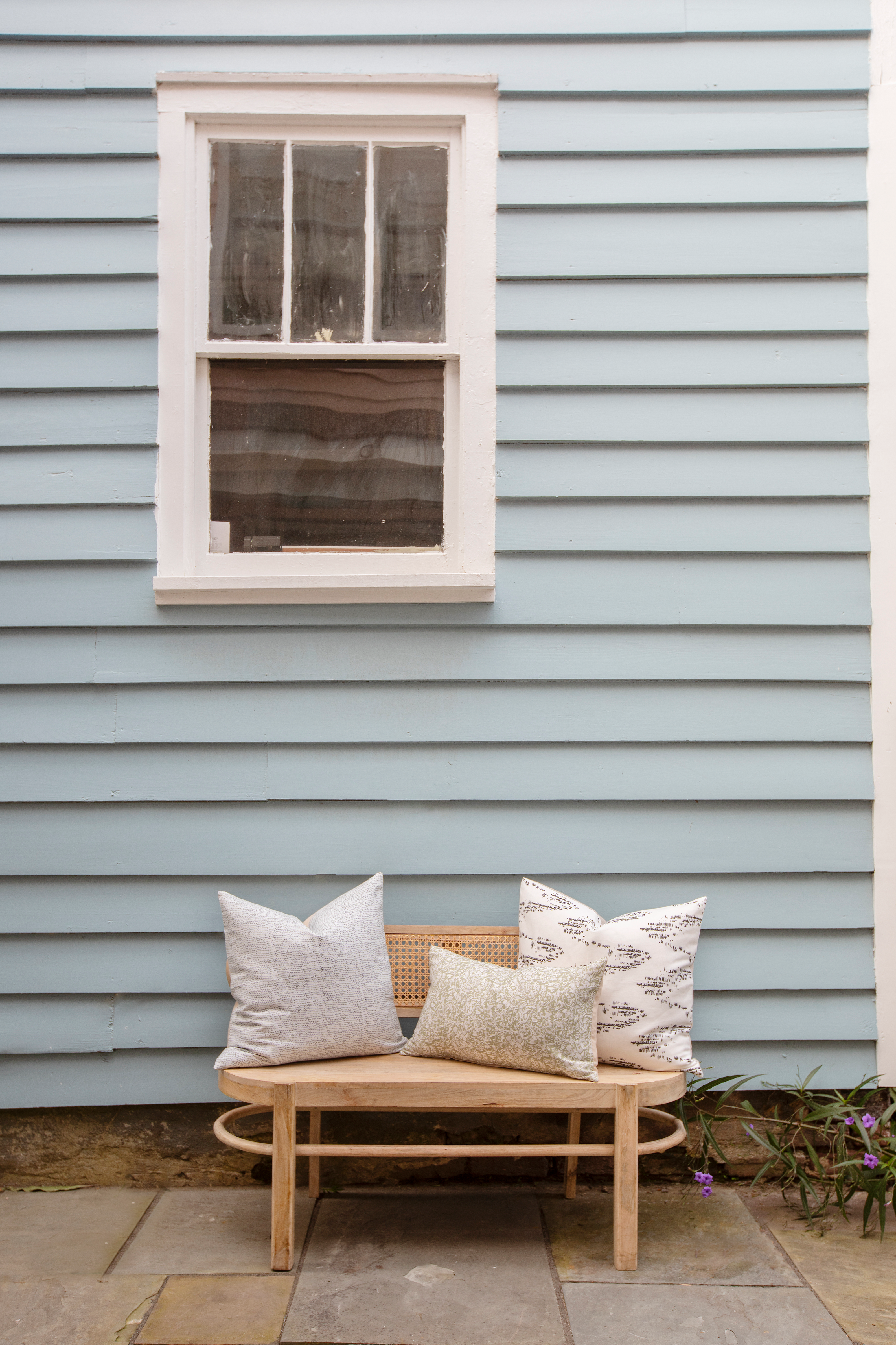 Salt Marsh pillow in Jet styled by Emily Daws – placed on a cane chair in a Charleston sunroom