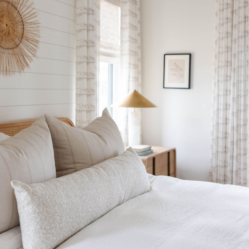 Sandbar pillow in Teak styled by Emily Daws – placed on a cane chair in a Charleston sunroom