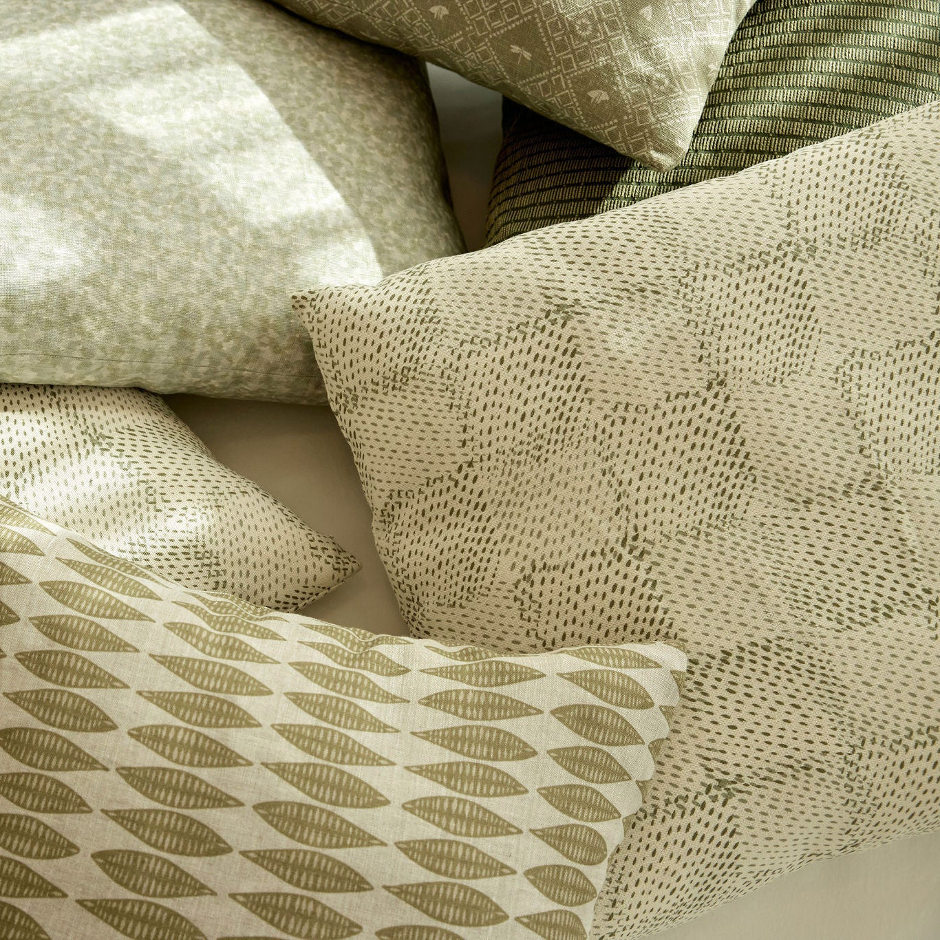 Speckled Check pillow in Cactus styled by Emily Daws – shown on a rustic bench with handmade quilts