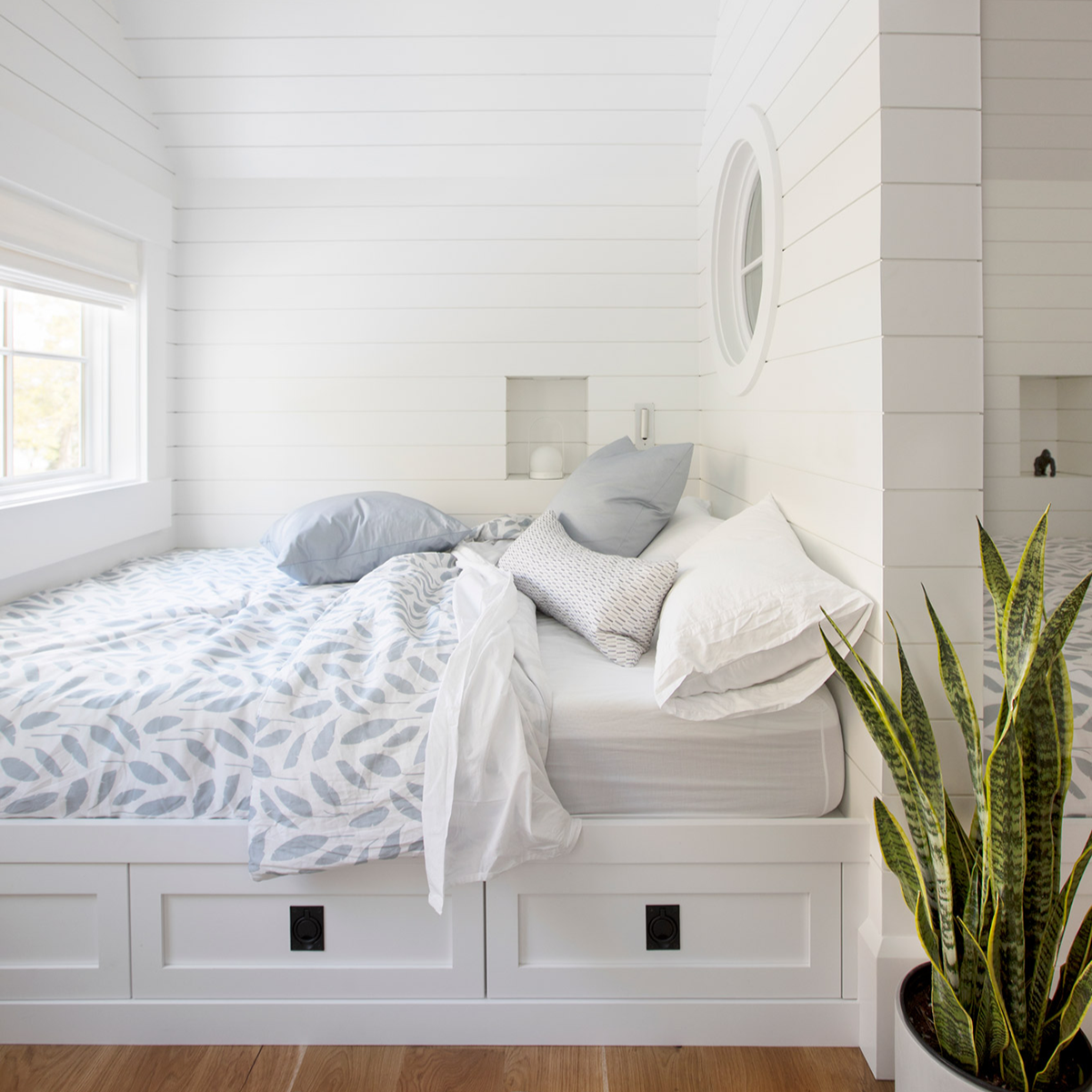 Sweetgrass pillow in Sapphire styled by Emily Daws – placed on a vintage settee in a Charleston cottage