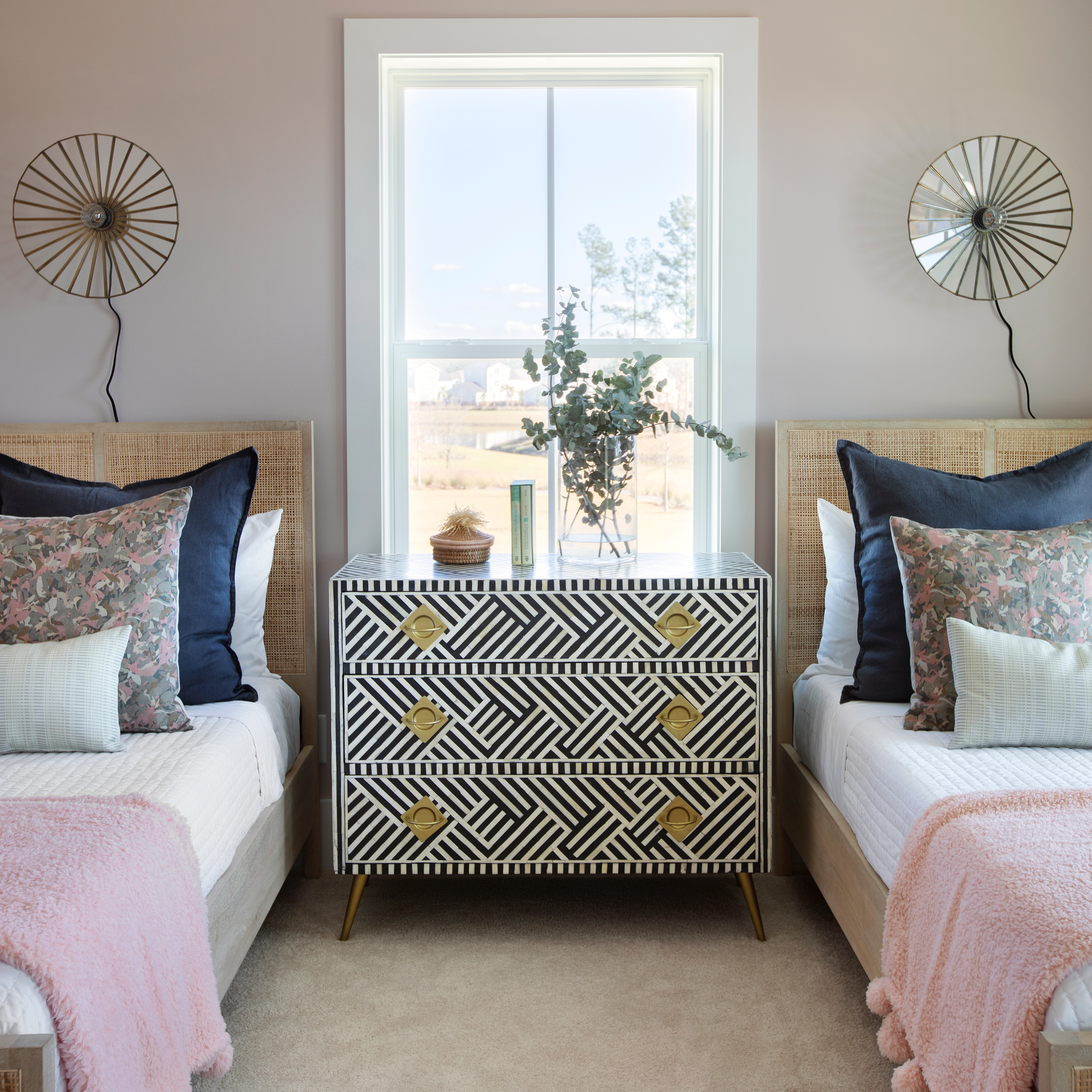 Thicket pillow in Rouge styled by Emily Daws – layered with quilts in a woodland bedroom setting