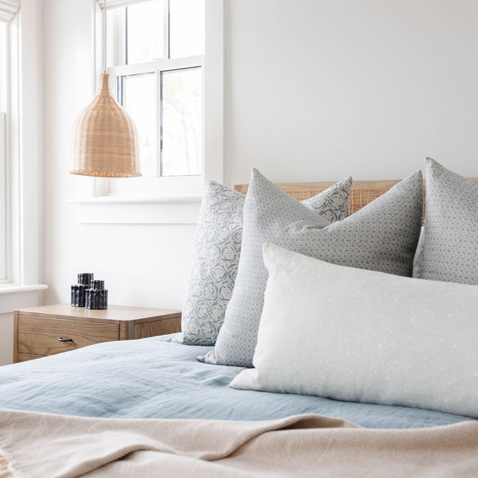 Tides pillow in Coast styled by Emily Daws – placed on a cane chair in a Charleston sunroom