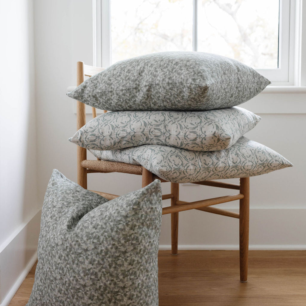 Tortoise pillow in Fig styled by Emily Daws β shown on a rustic bench with handmade quilts