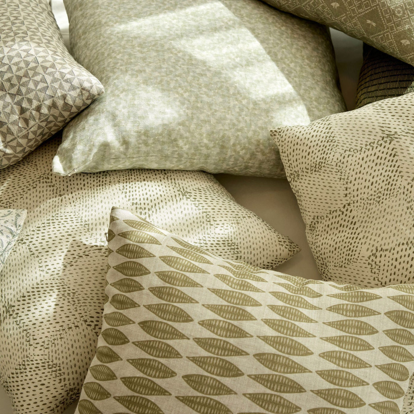 Tortoise pillow in Honeydew styled by Emily Daws β shown on a rustic bench with handmade quilts