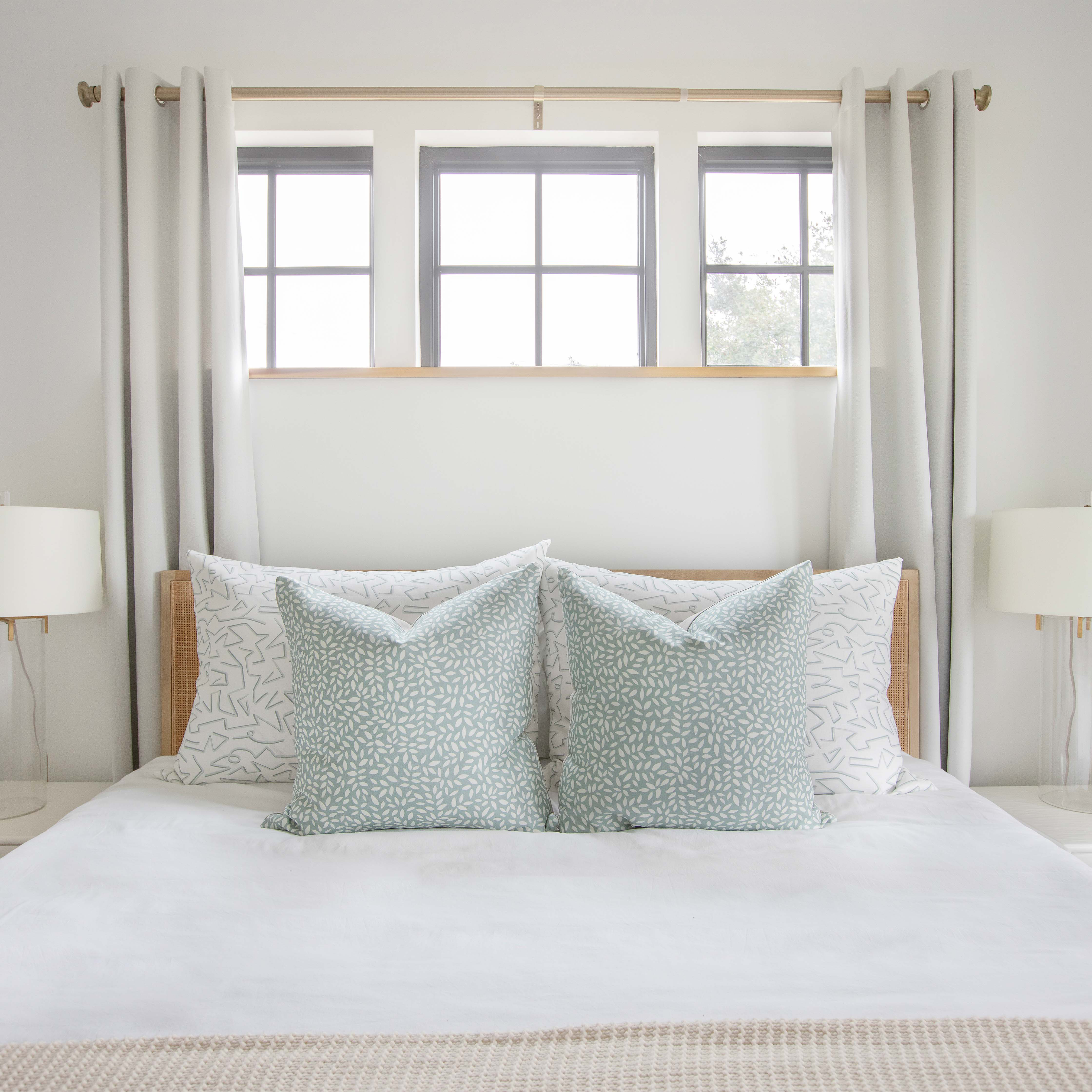 Bedroom vignette featuring Emily Daws pillows, styled with heirloom-inspired fabrics for boutique interiors.