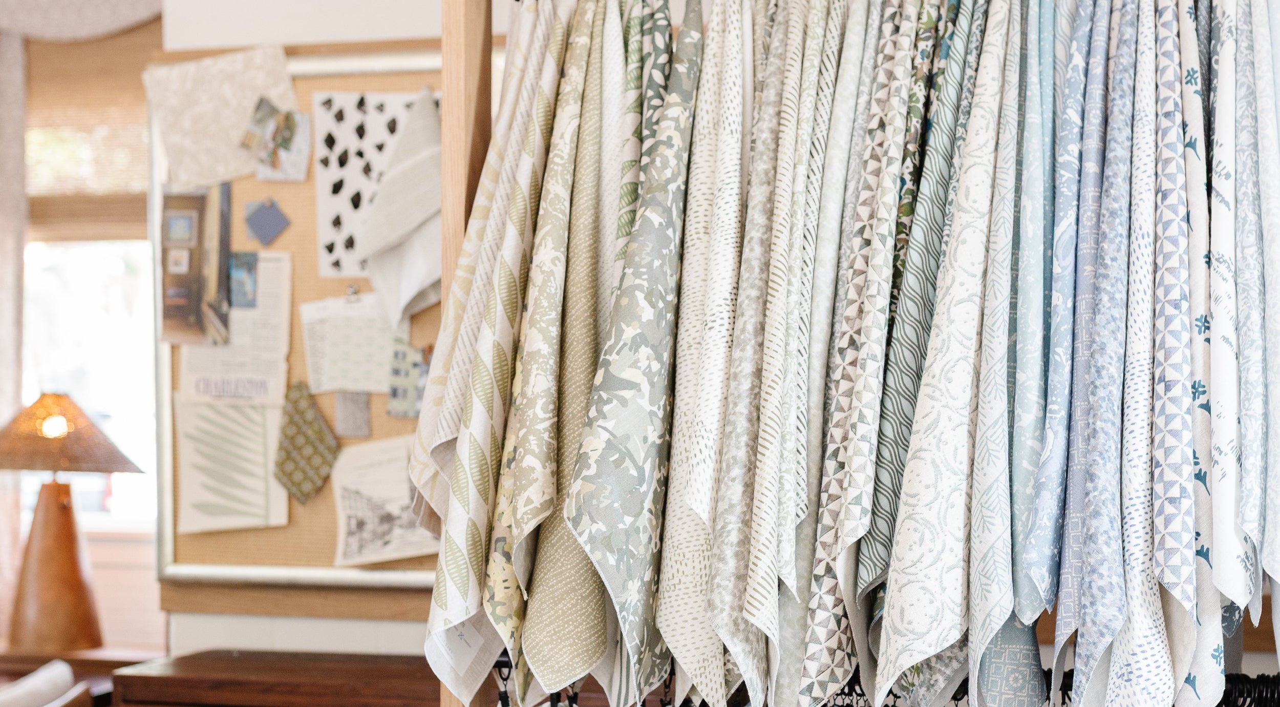 Emily Daws fabric swatches hanging on a rack with a room interior in the background
