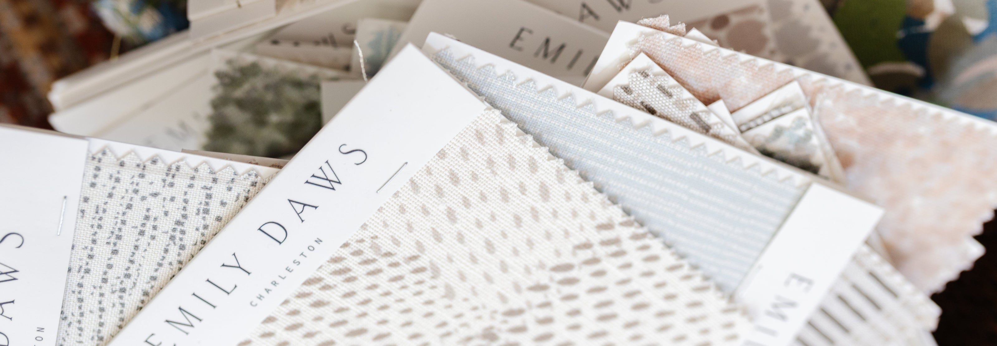 View of Emily Daws linen fabric swatches in soft colors and coastal patterns.