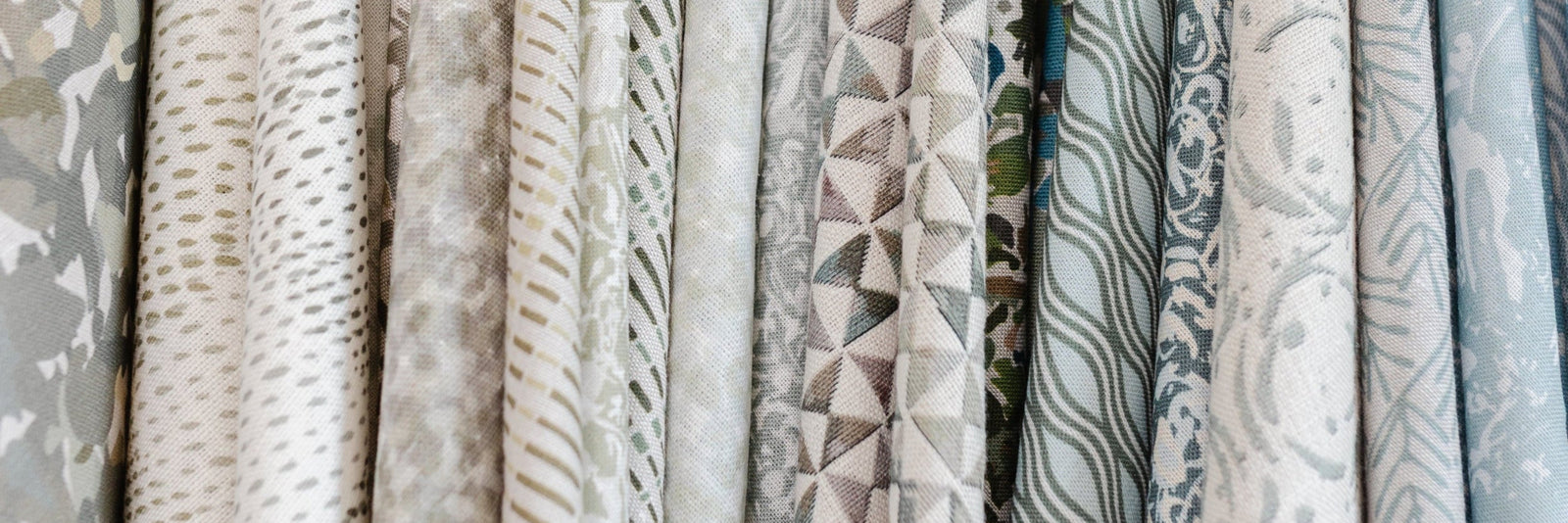 Collection of small-batch fabric wings in neutral colors hanging in Emily Daws Showroom.